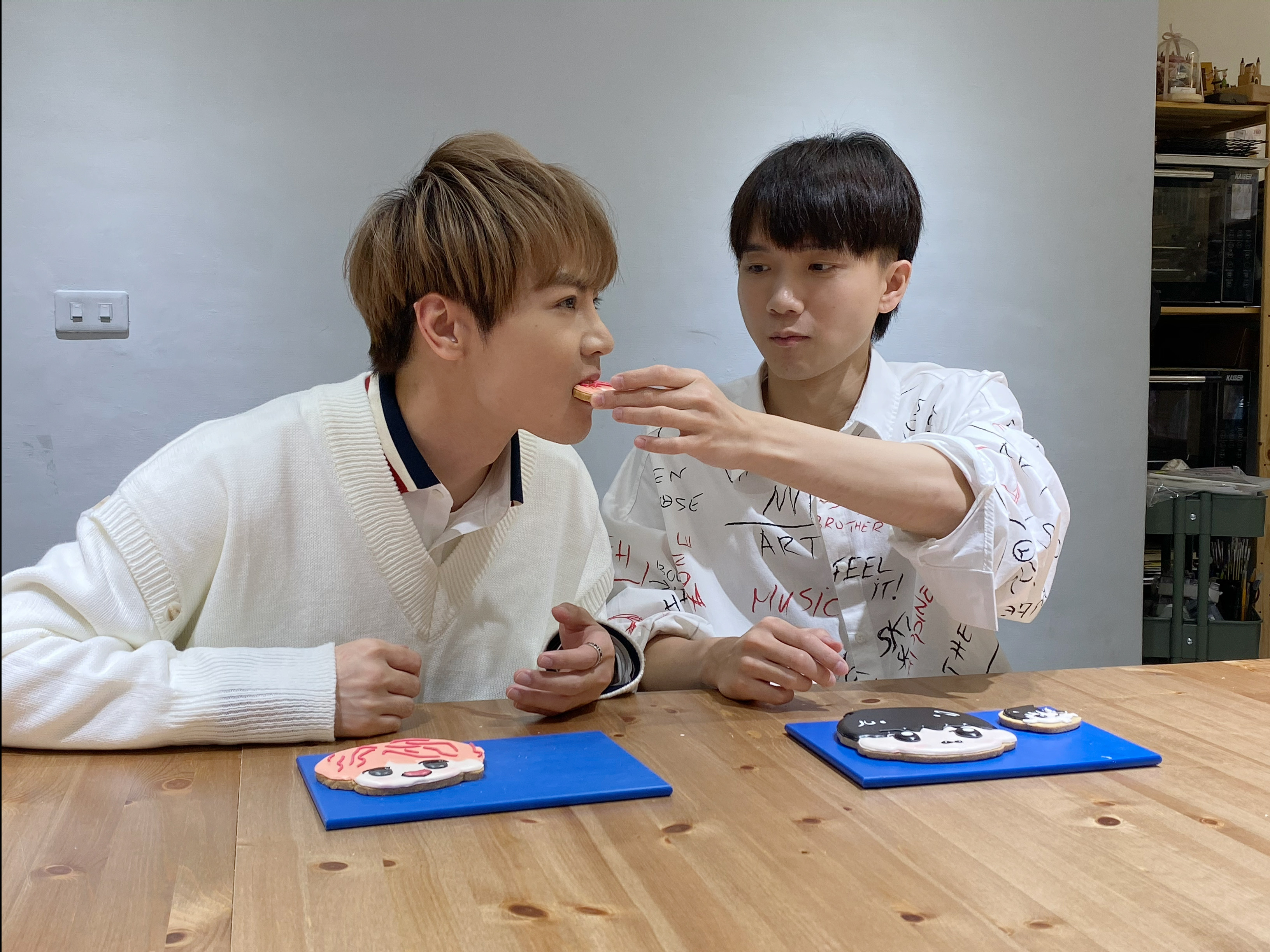 古曜威與哲哲兩人，在Vlog中互餵食Q版餅乾。（單純夢想提供）