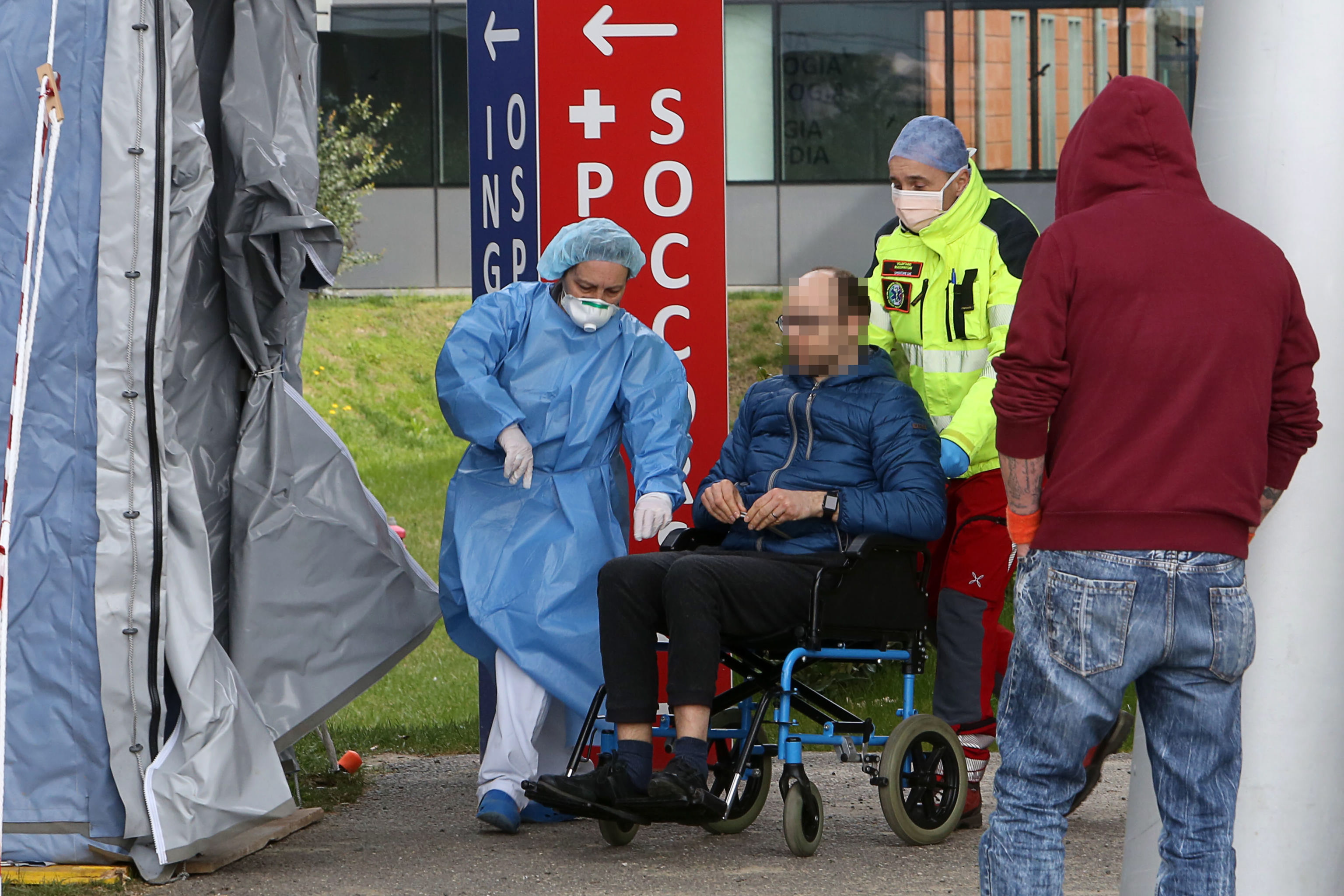 歐美地區武漢肺炎疫情大幅升溫，圖為民眾在義大利北部巴都亞市的檢驗站排隊等候檢疫。（東方IC）