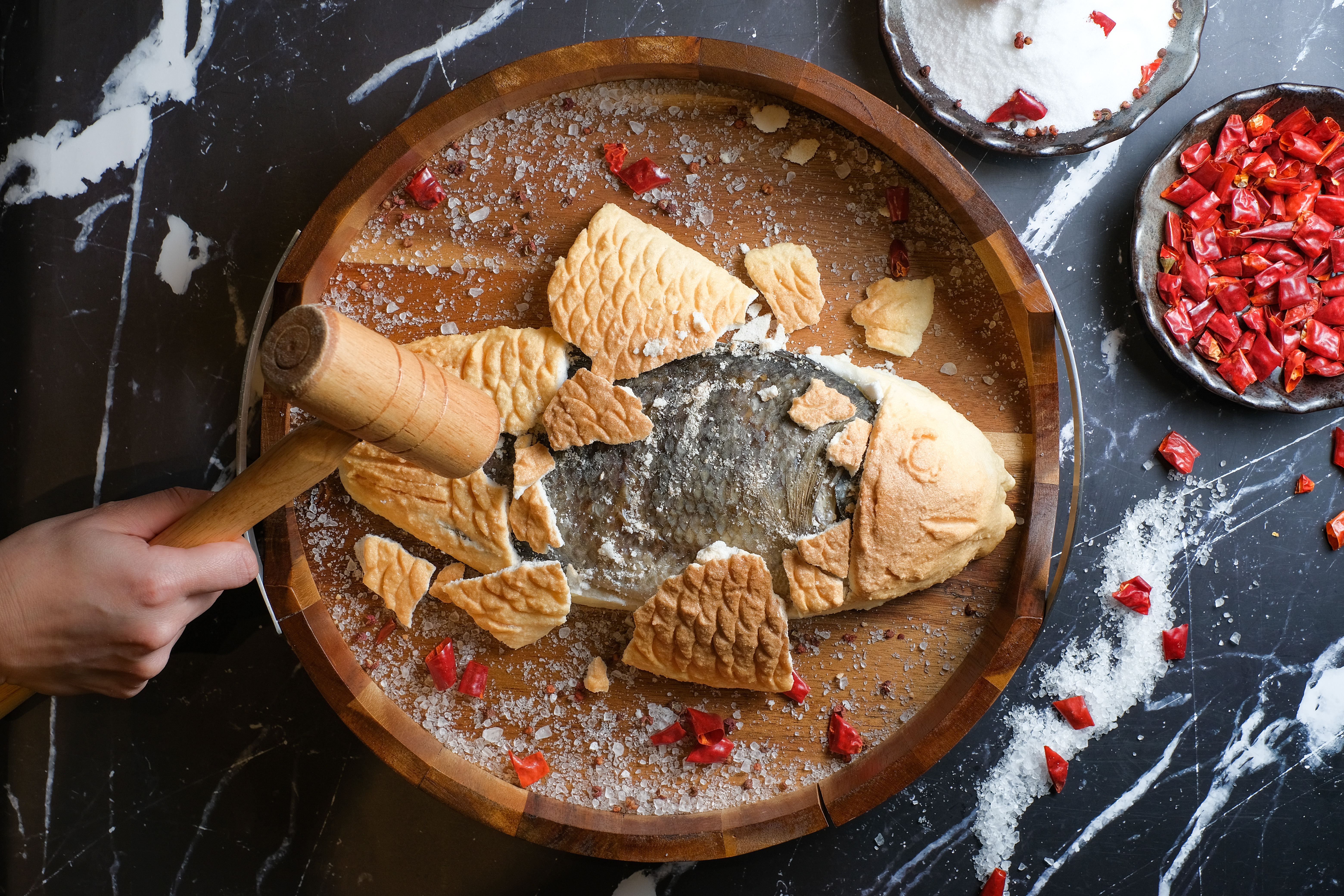 「鹽焗台灣鯛」會附一根小槌子，讓客人敲開敷在魚上的模型，再送進廚房去皮。（680元／份）