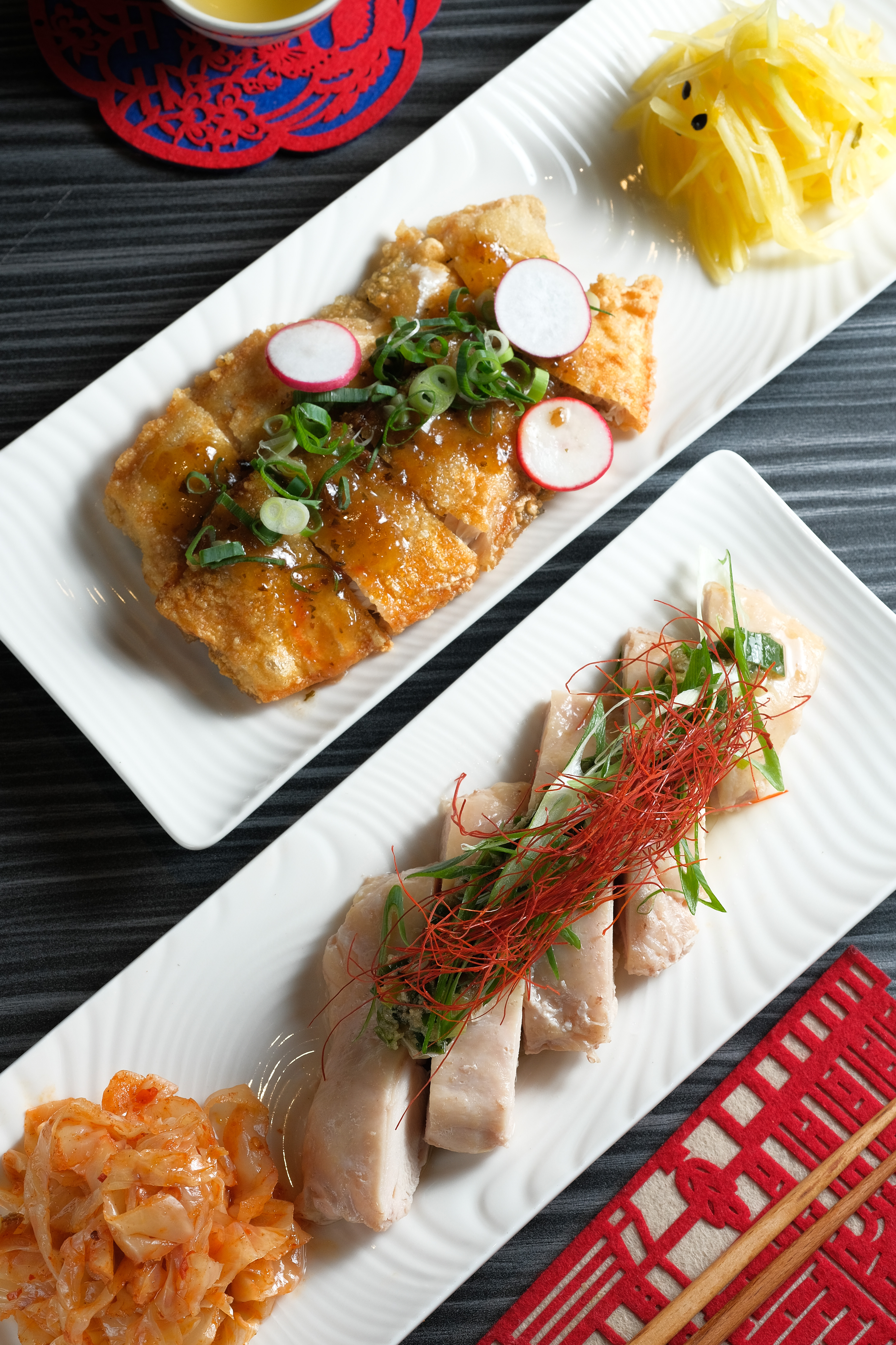 「蔥油雞腿」（前，250元／份）是柔嫩甜心，「香酥台南虱目魚肚」（後，320元／份）和紫蘇梅醬，成了暗藏少女心的炸物。