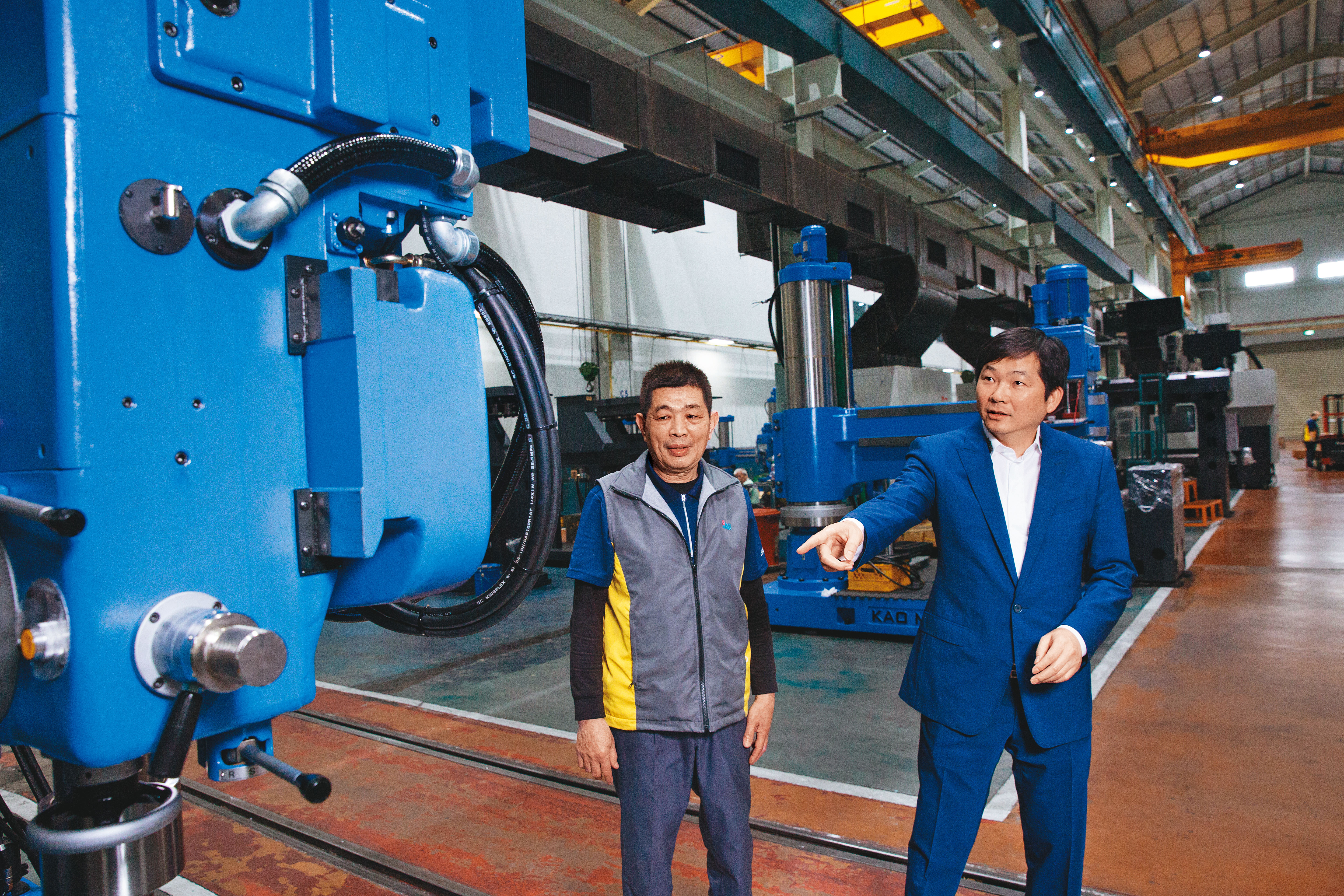 張仕育（右）從小在工廠長大，國中時就被父親叫去學配電、鎖螺絲，對機械設備相當熟稔。