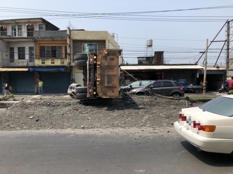 台一線新埤路段中午發生一起嚴重車禍,肇事砂石車翻覆,砂石散落一地。(翻攝畫面)