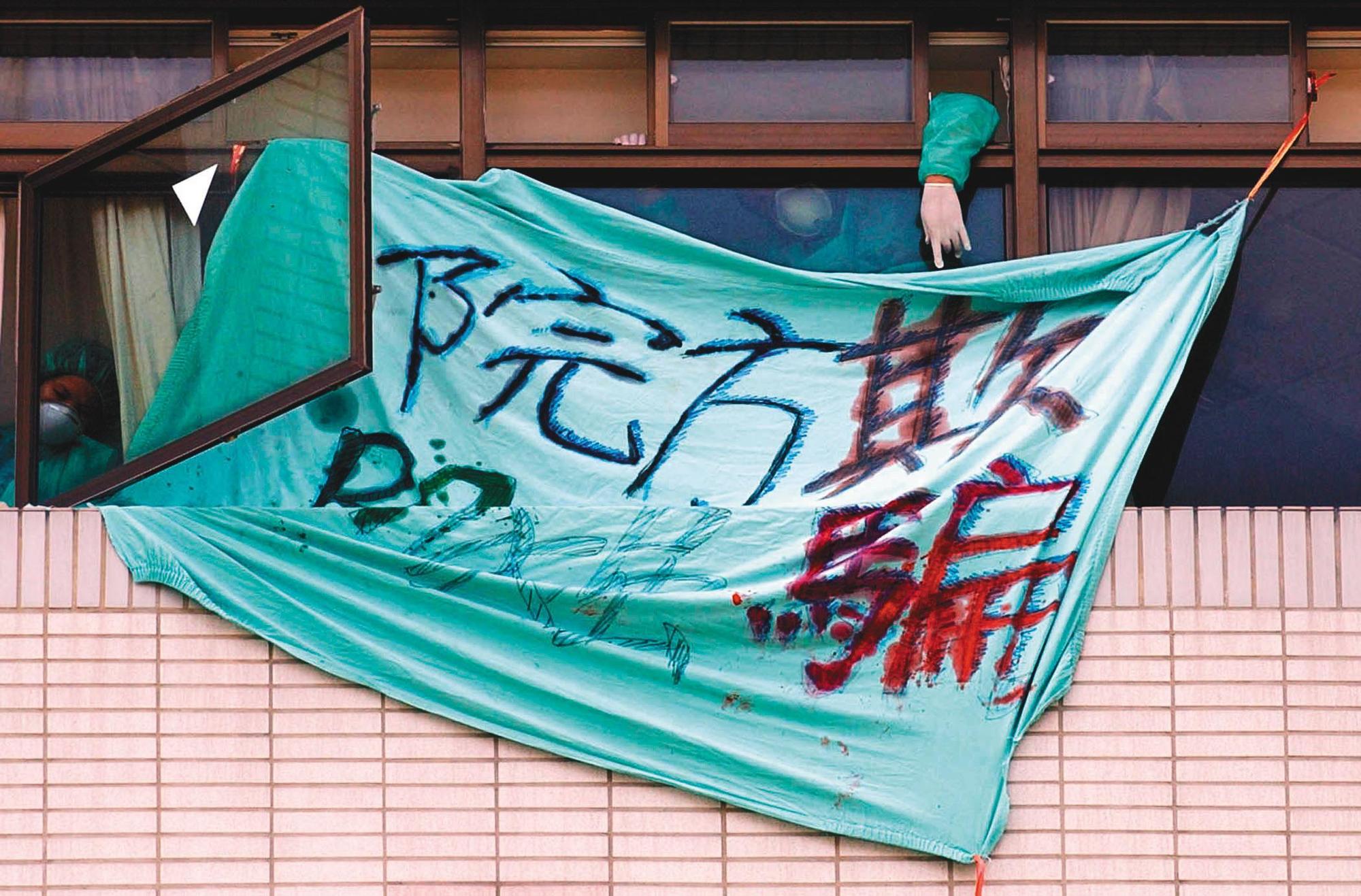 2003年，因SARS疫情台北市和平醫院封院，被隔離的病患家屬在窗外拉布條抗議院方隱瞞疫情。（中央社）