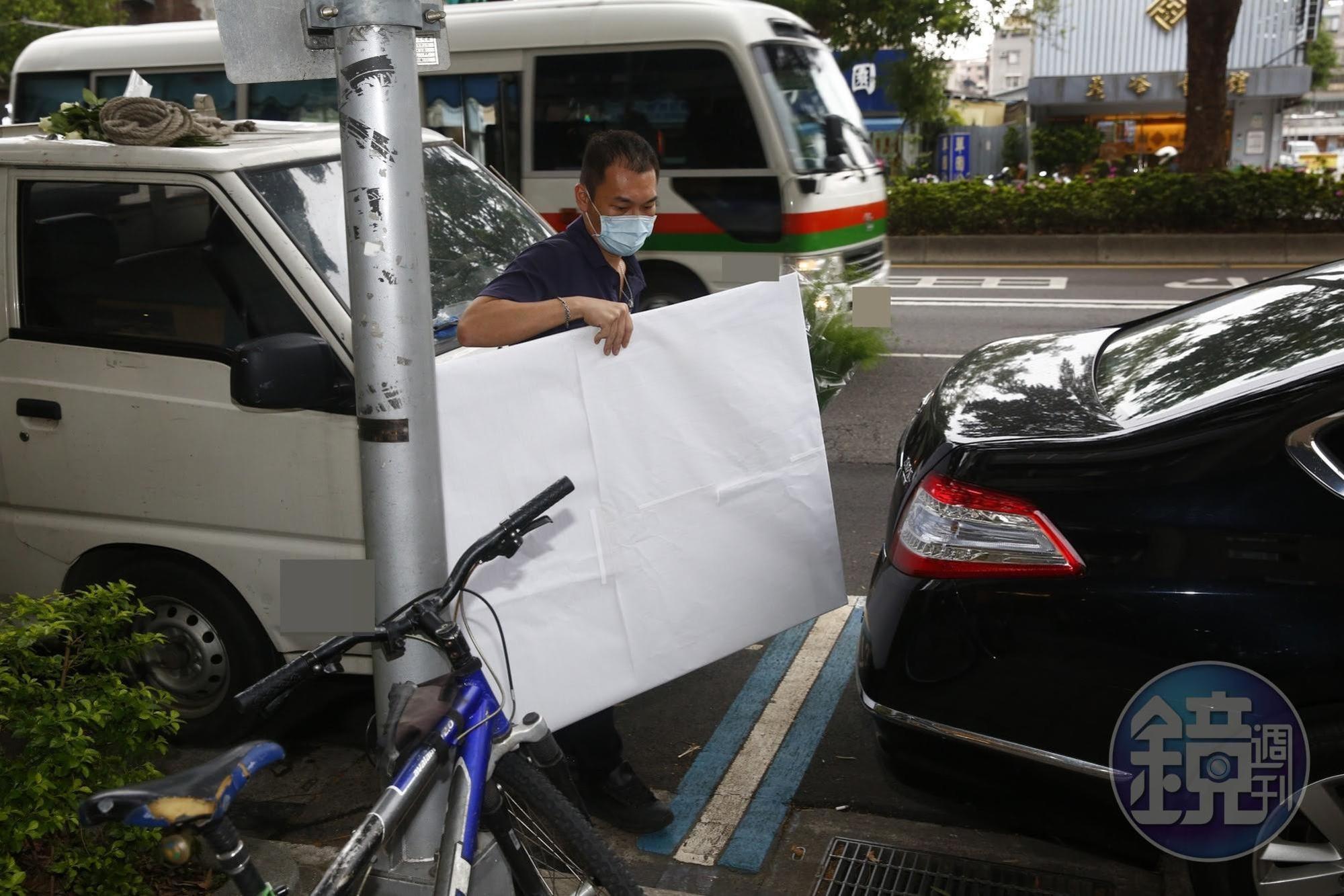疑似劉真的遺照在白紙包覆下由工作人員送達靈堂。