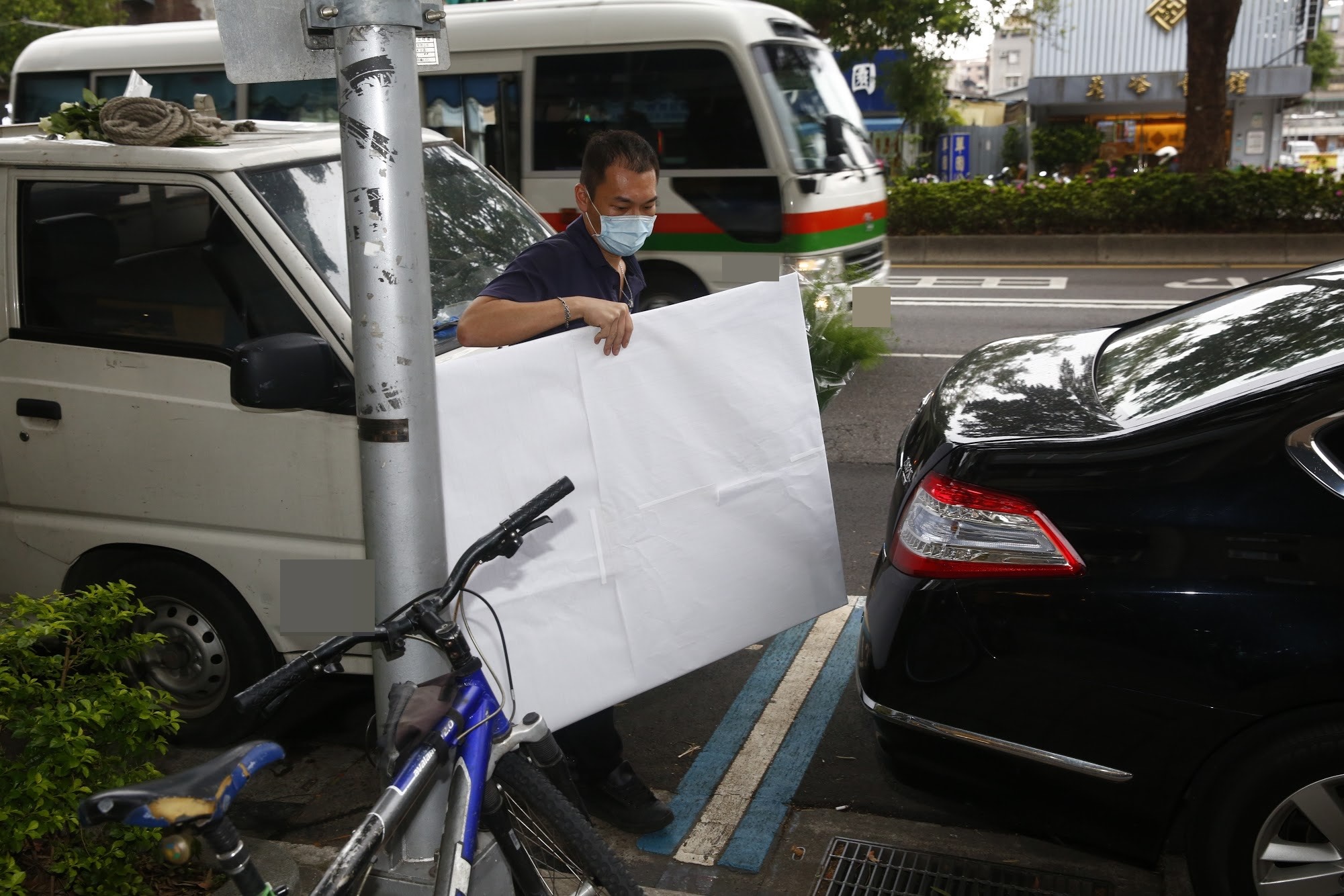 疑似劉真的遺照在白紙包覆下由工作人員送達靈堂。