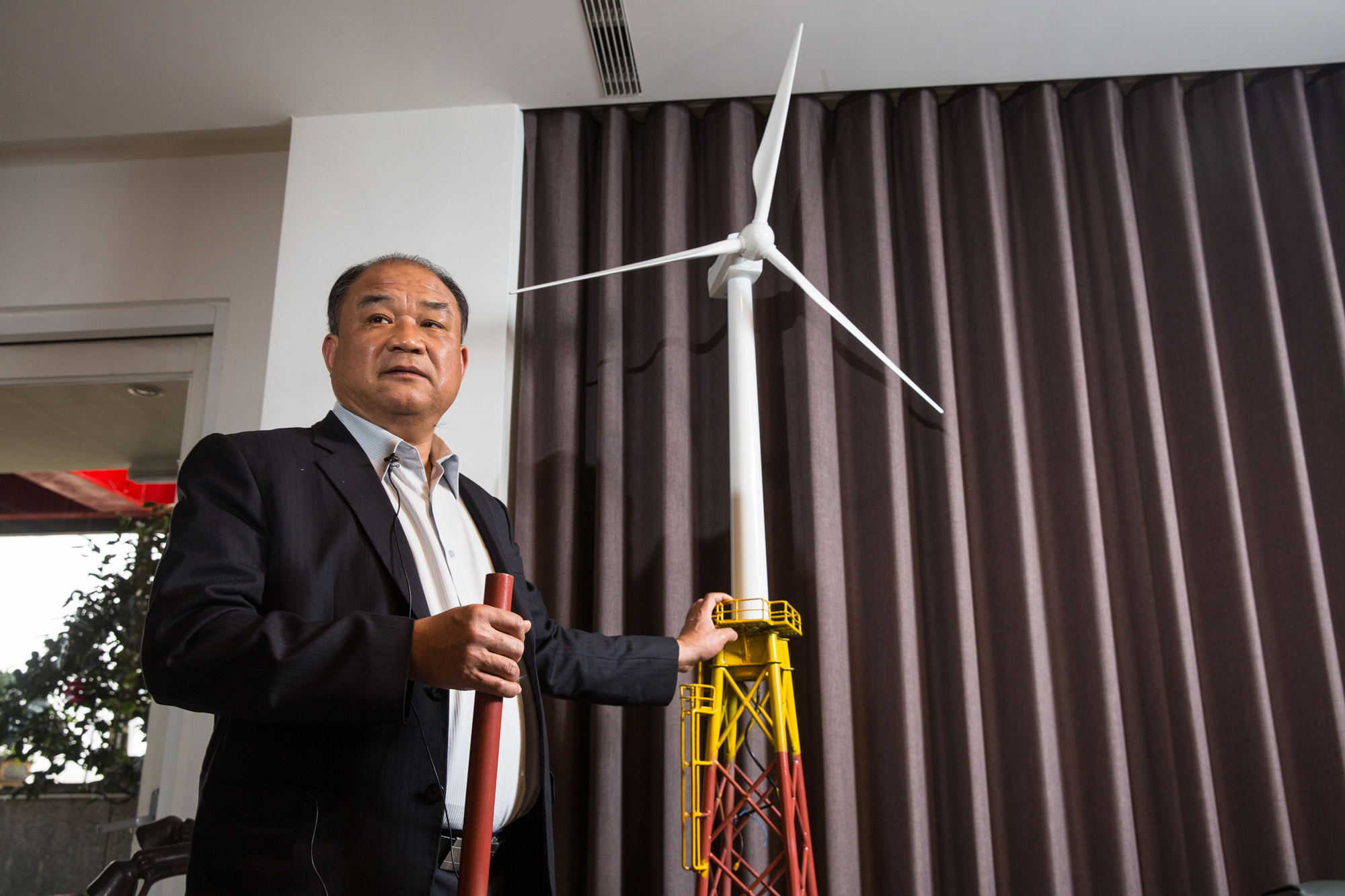 賴文祥的辦公室擺著一座等比縮小的風機模型，目前世紀鋼鐵製作的基樁（Pin Pile）與塔架（Jacket）還特別漆上顏色標示。