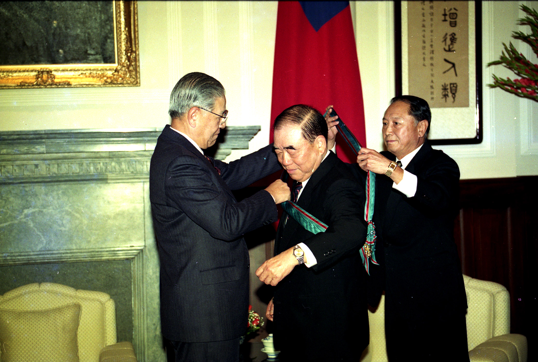 1993年2月26日，時任總統李登輝（左）頒勳章給當時即將卸任的行政院長郝柏村（中）。