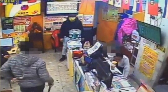 蕭男被龔男持刀追砍,躲入一旁彩券行。(翻攝畫面)