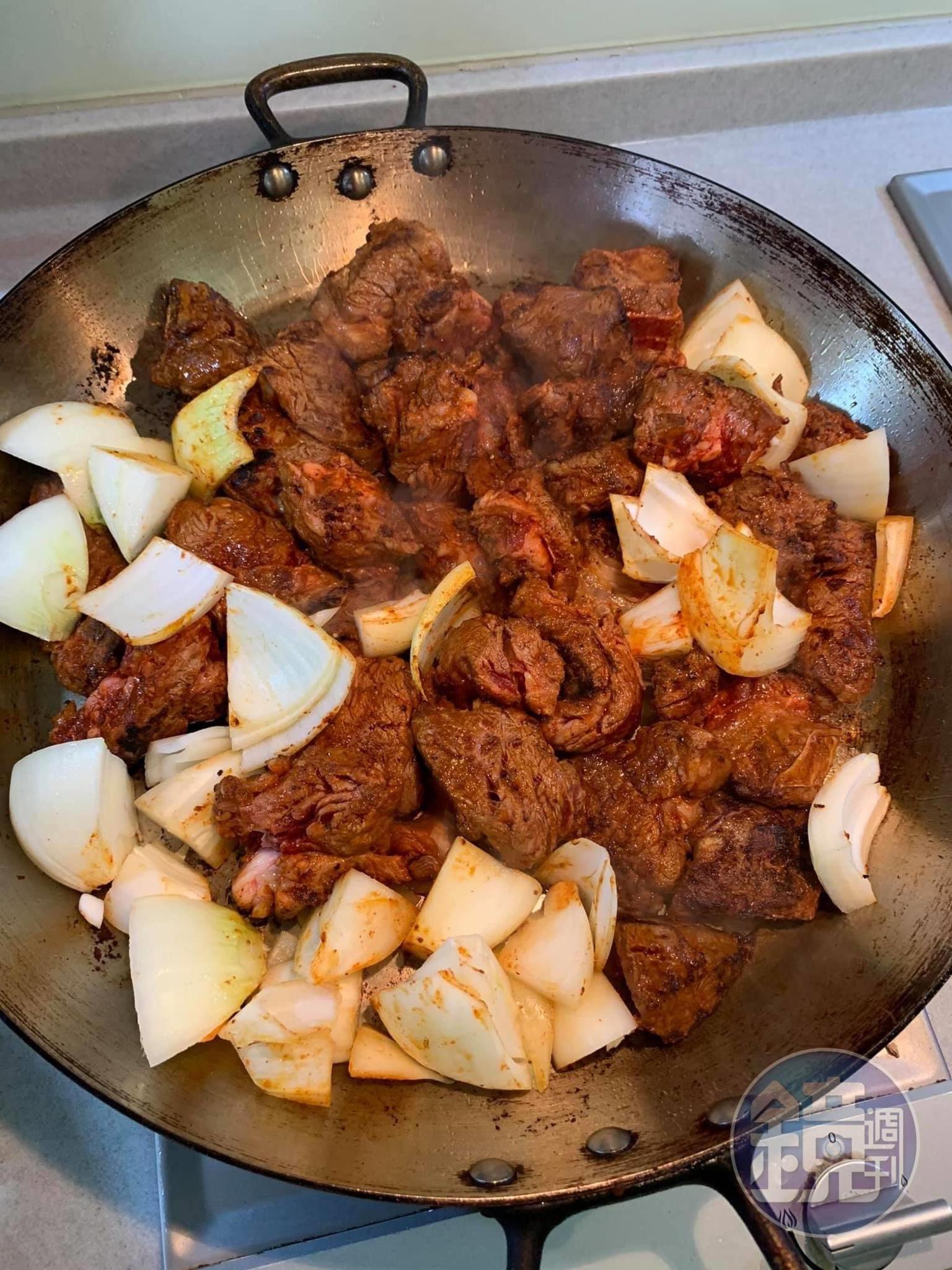 牛肉表面略微炒熟後，接著炒洋蔥。