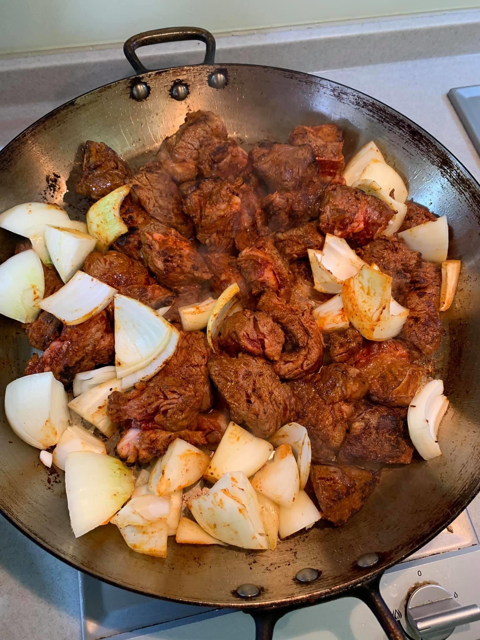 牛肉表面略微炒熟後，接著炒洋蔥。