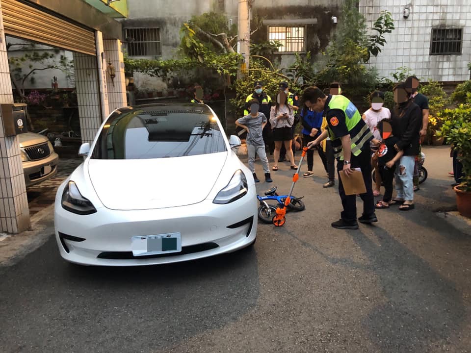 特斯拉轎車遭6歲童騎車撞上，警方到場勘驗。（翻攝臉書）