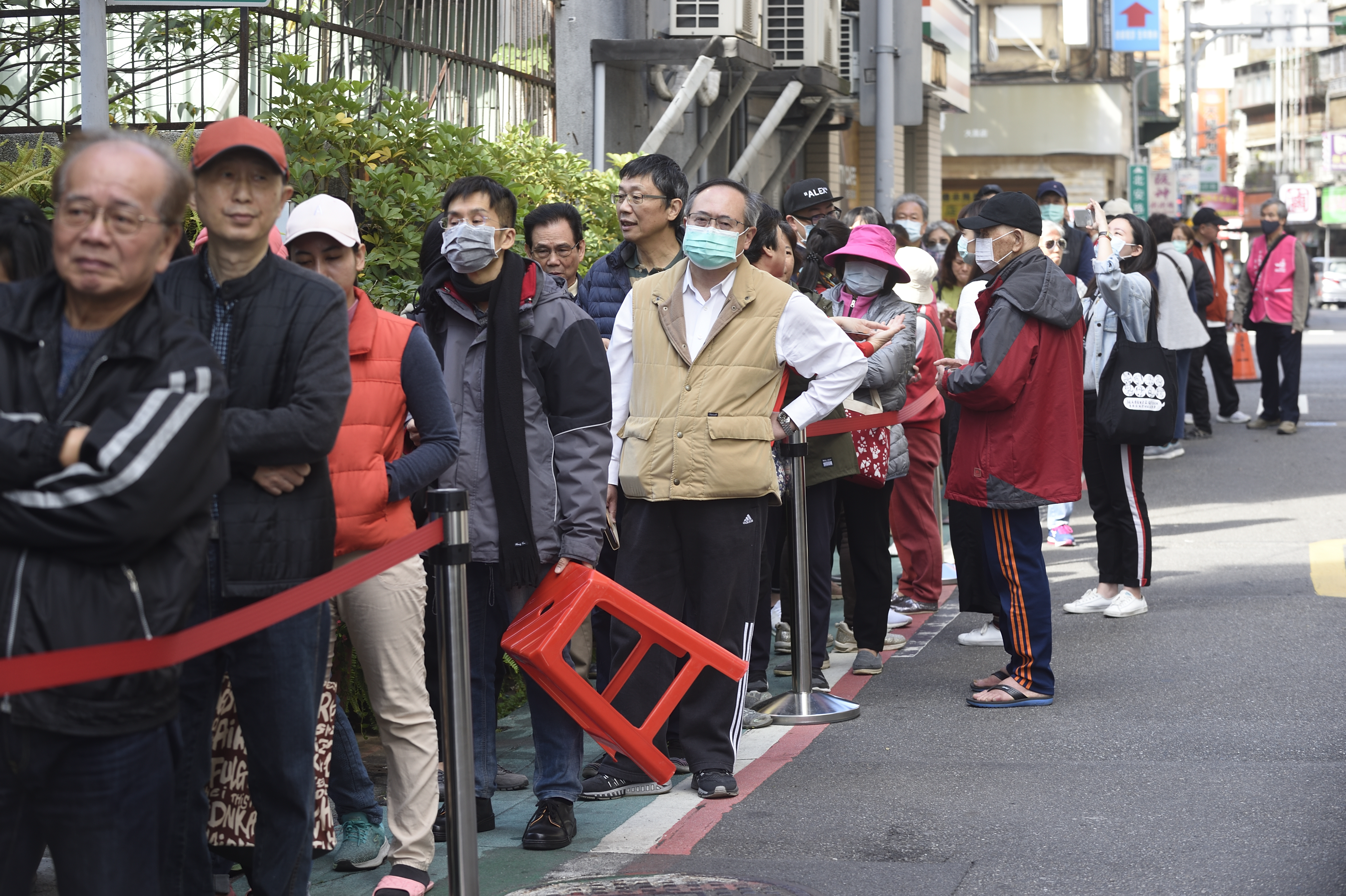 許多台灣民眾攜帶健保卡到藥局排隊購買口罩。（本刊資料照）
