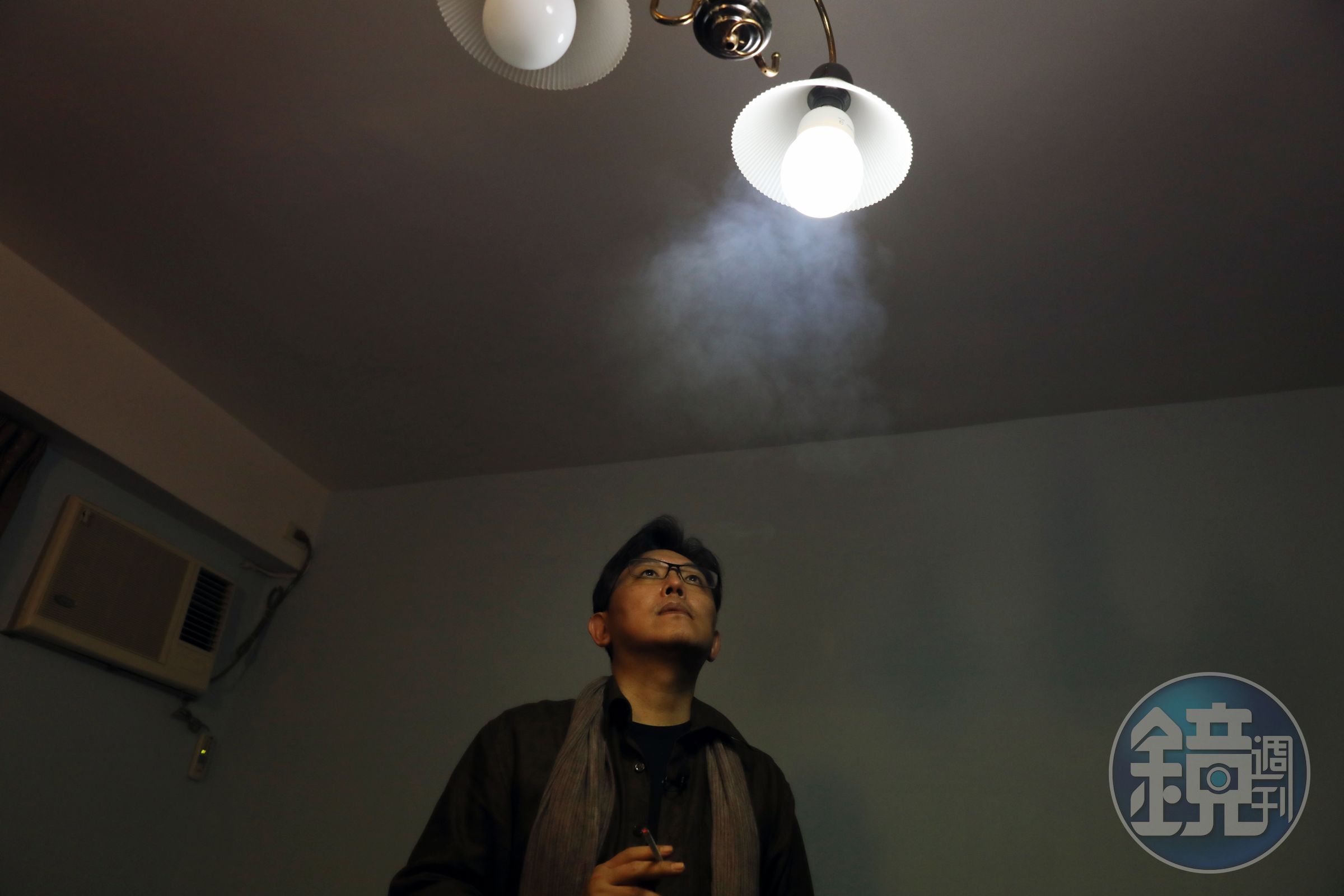 郭強生抽菸。他的老家空闊，家具或許隨家人的離散也按次減少，在空屋裡，他用創作和自己對話。
