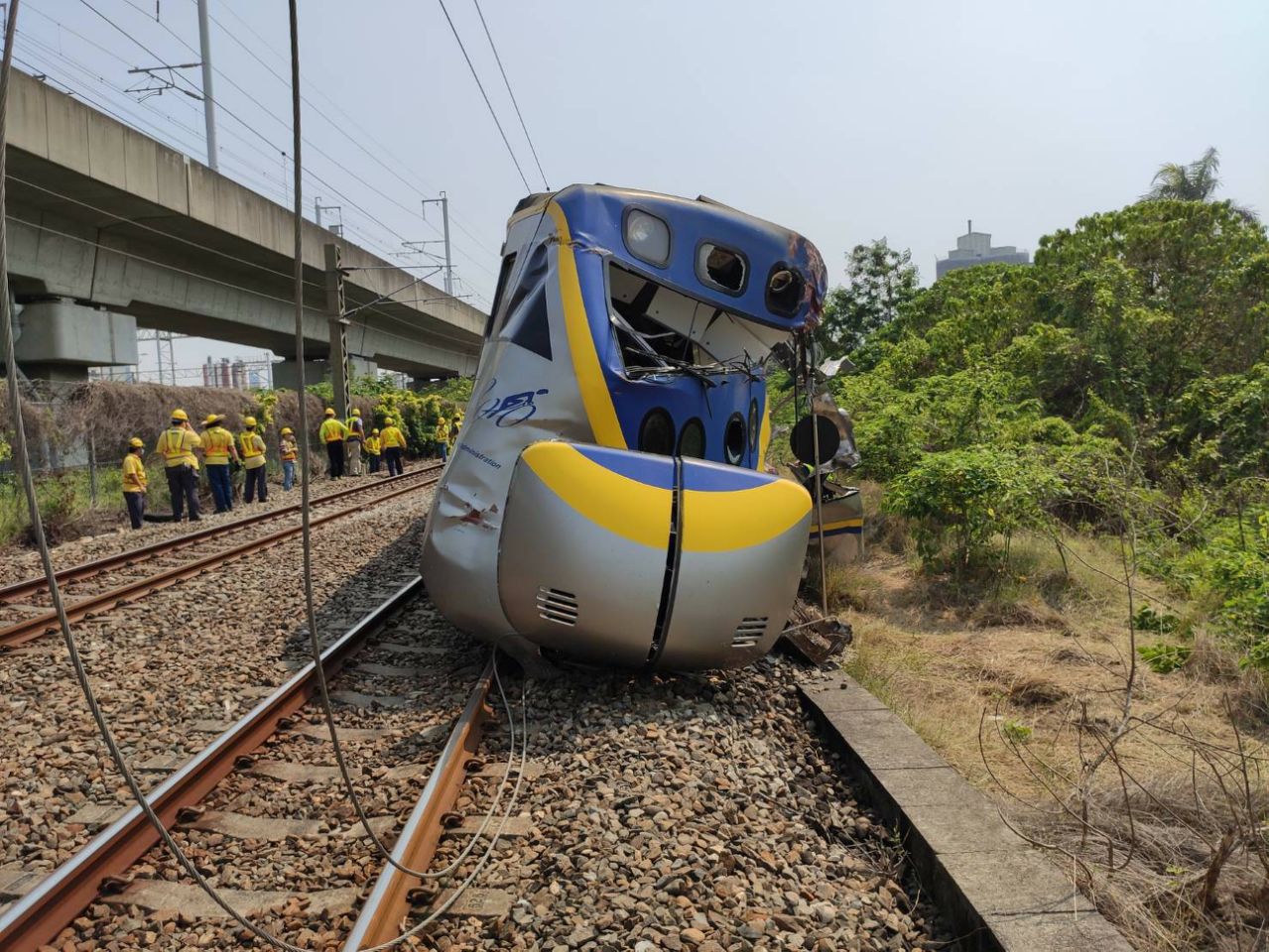 聯結車入侵平交道，區間車撞上導致三節車廂出軌、車頭全毀、人員受傷。（台鐵提供）