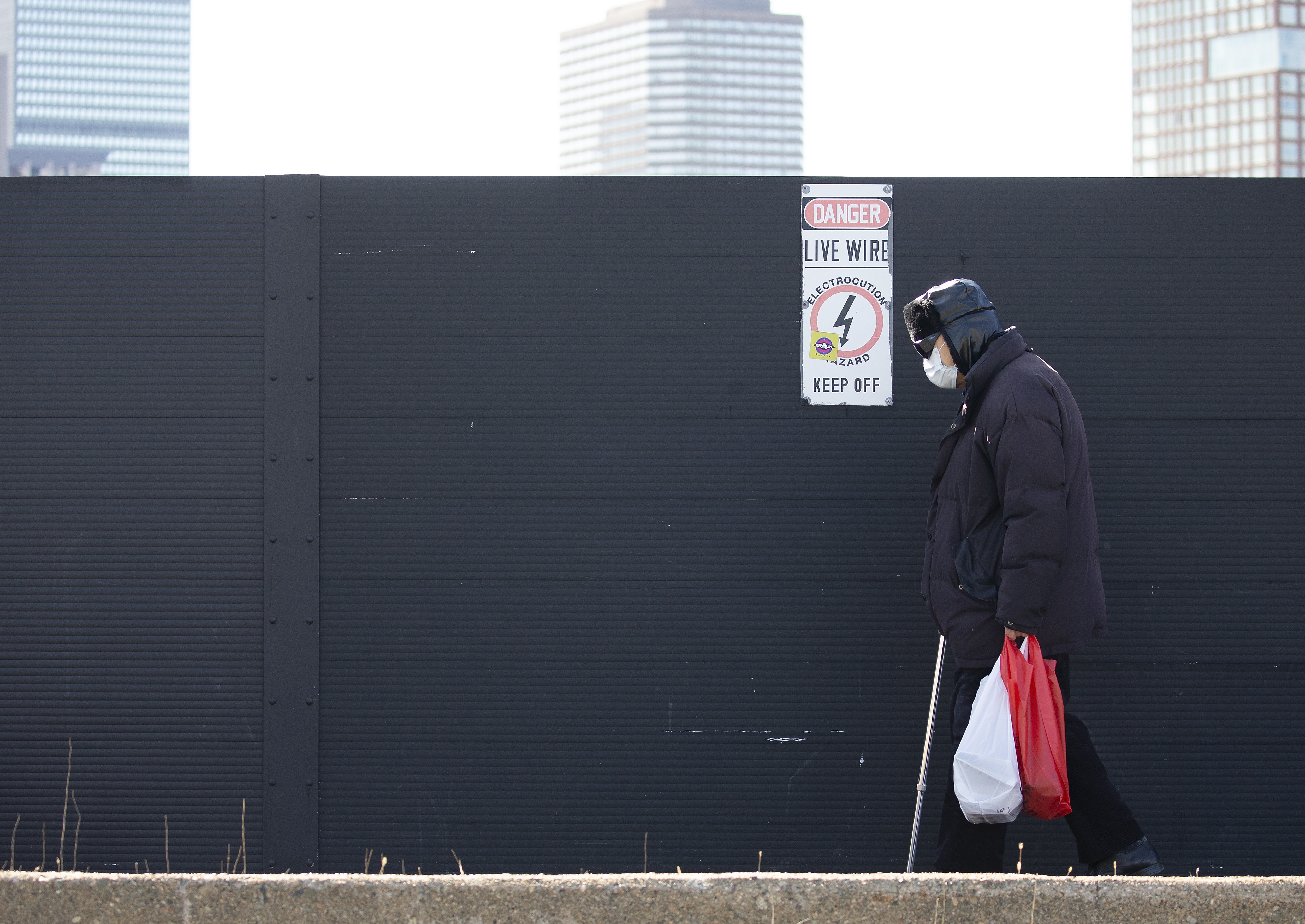 美國疫情封鎖期間，波士頓一名男子戴口罩走過空蕩無人的街道。（東方IC）