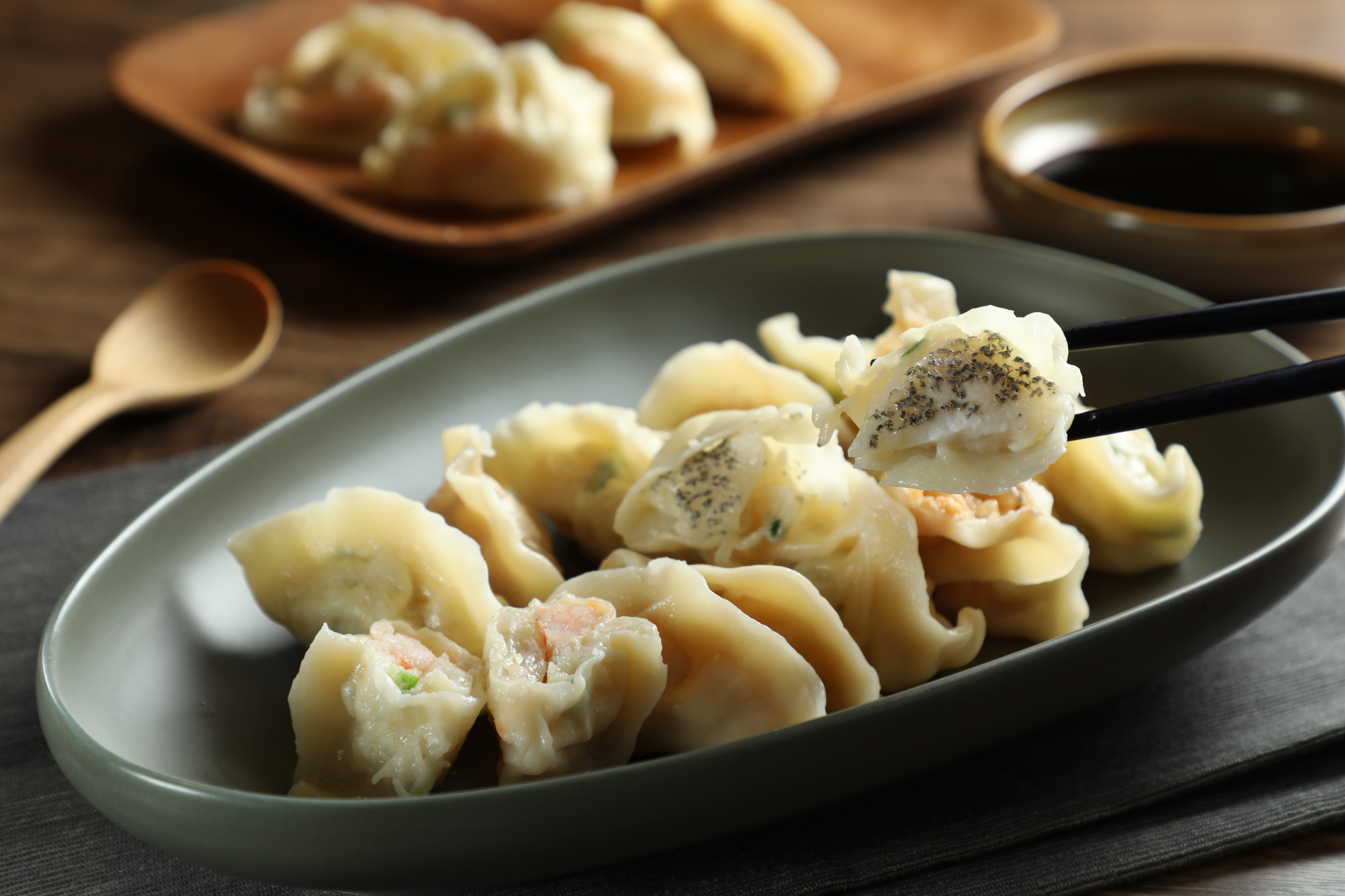包整塊帶皮石斑魚肉的「龍虎斑鱻餃」（右，270元／12顆）堪稱宅在家吃水餃的巔峰，另還有「韓式泡菜」、「韭黃蝦仁」等口味可選擇（220元／12顆）。