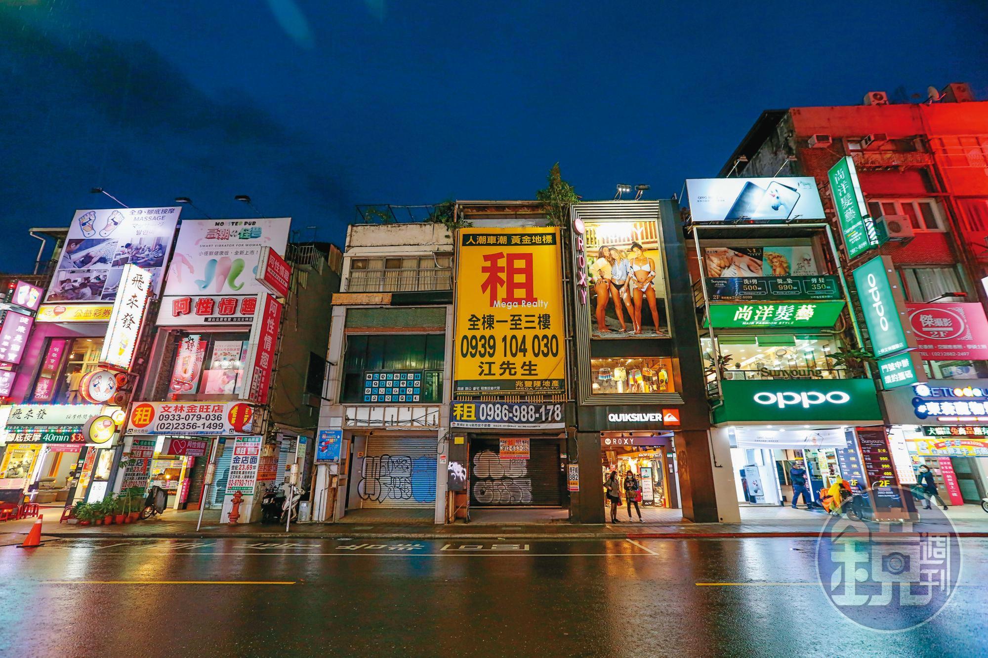 士林夜市商圈大路旁的透天店面乏人問津，斗大招租布幕格外顯眼。圖為文林路。
