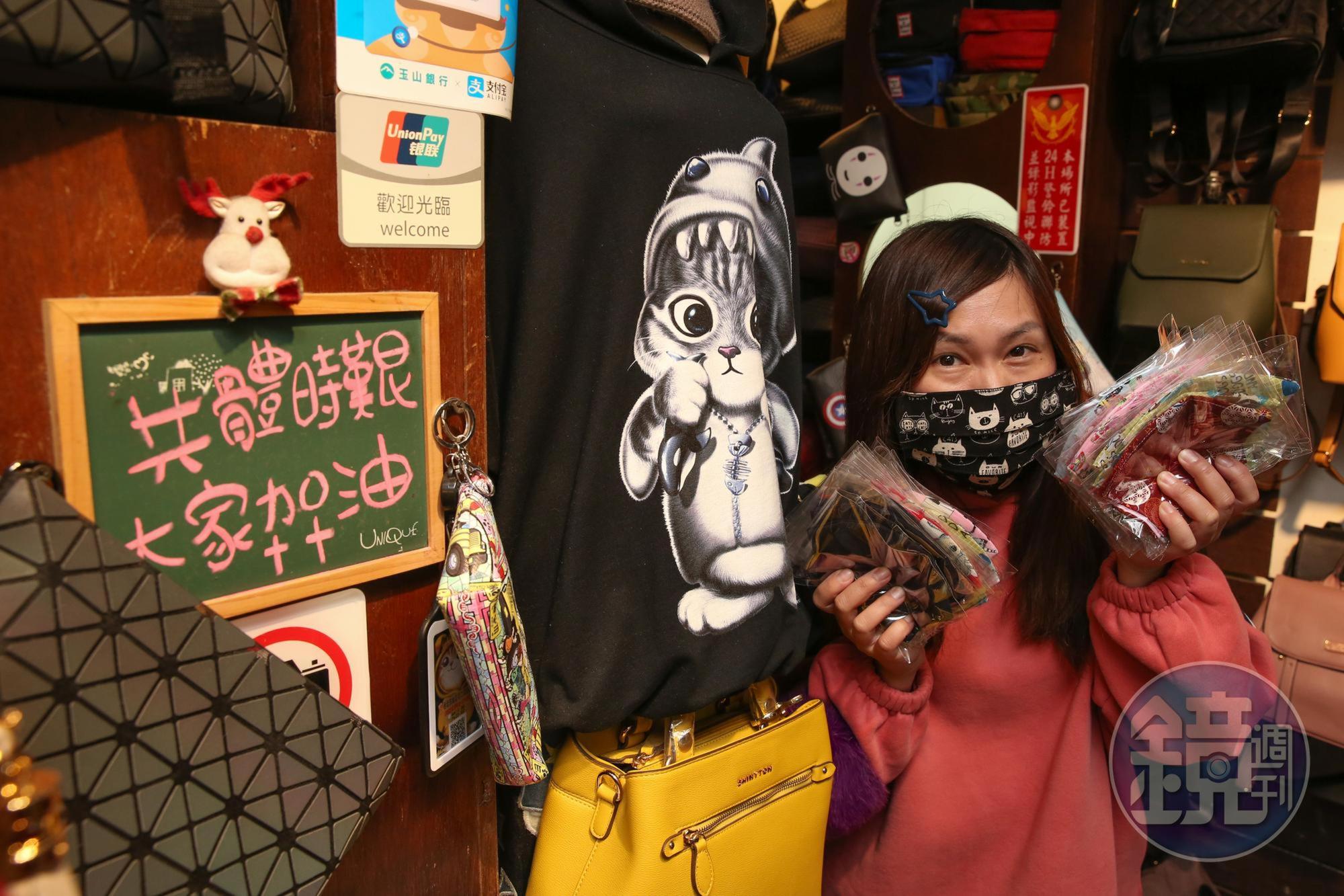「夜上海」服飾店的老闆娘張玲華受訪,身旁放著一塊寫了「共體時艱,大家加油」的小黑板。