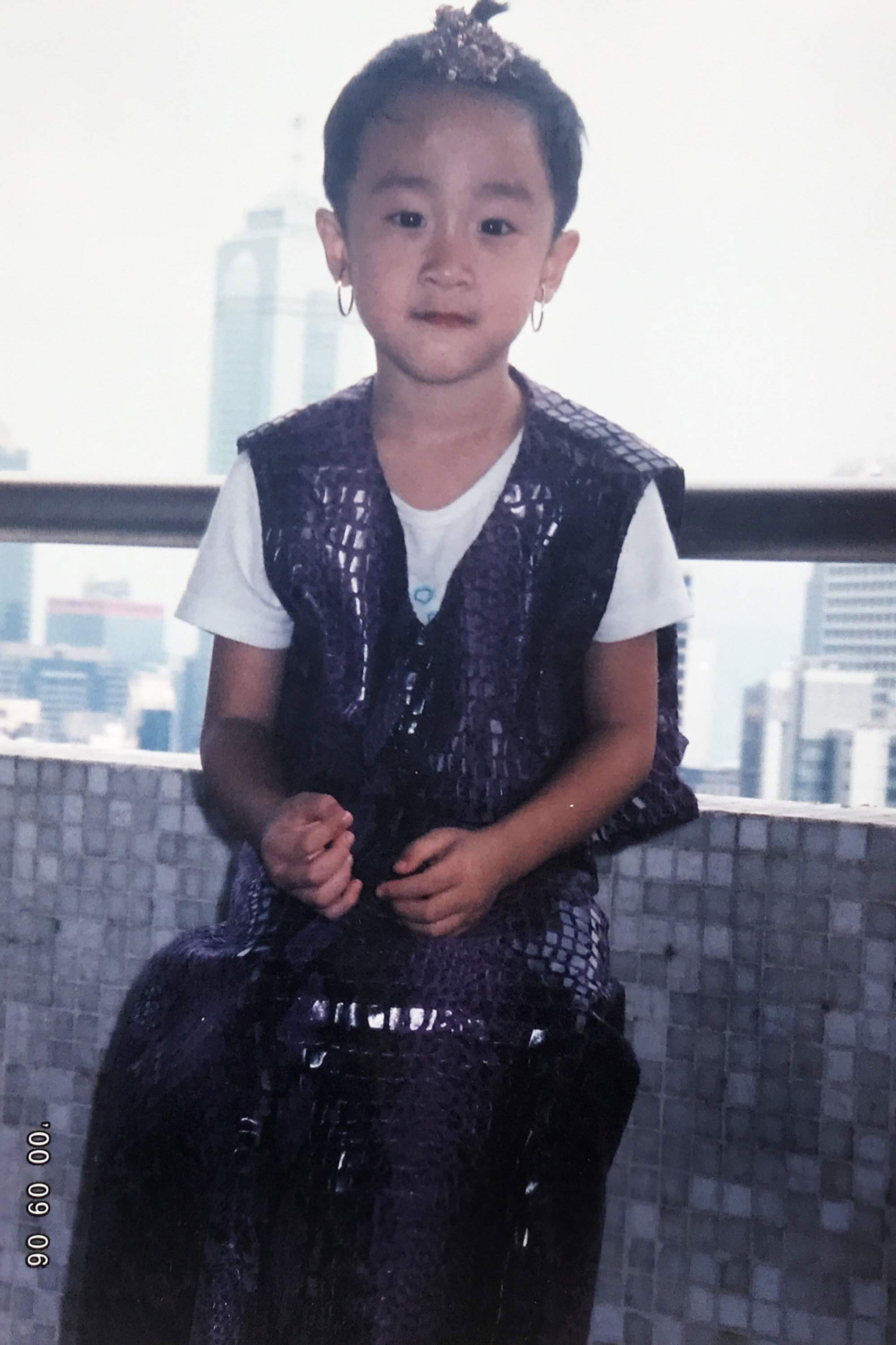 曹米駬在美國出生,香港長大,6歲才搬到台灣。圖為在香港時,保母燙完衣服問他不要穿看看?他穿上後,還綁頭髮戴耳環,他說:「就好玩。」(曹米駬提供)