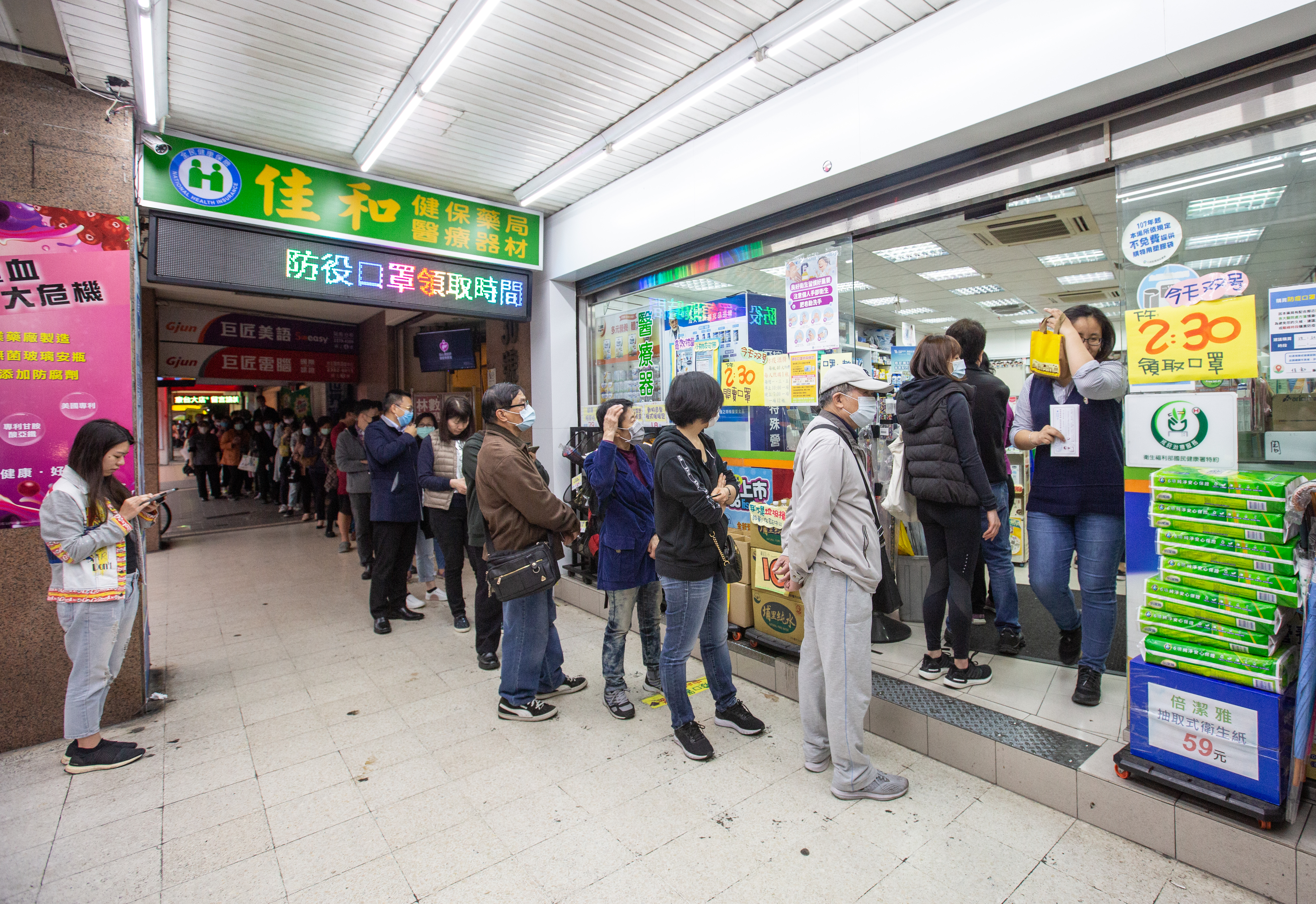 食藥署署長、指揮中心研究組副組長吳秀梅證實，19日起每週日就不配送口罩；圖為民眾在藥局前排隊買口罩，示意圖。（本刊資料照）