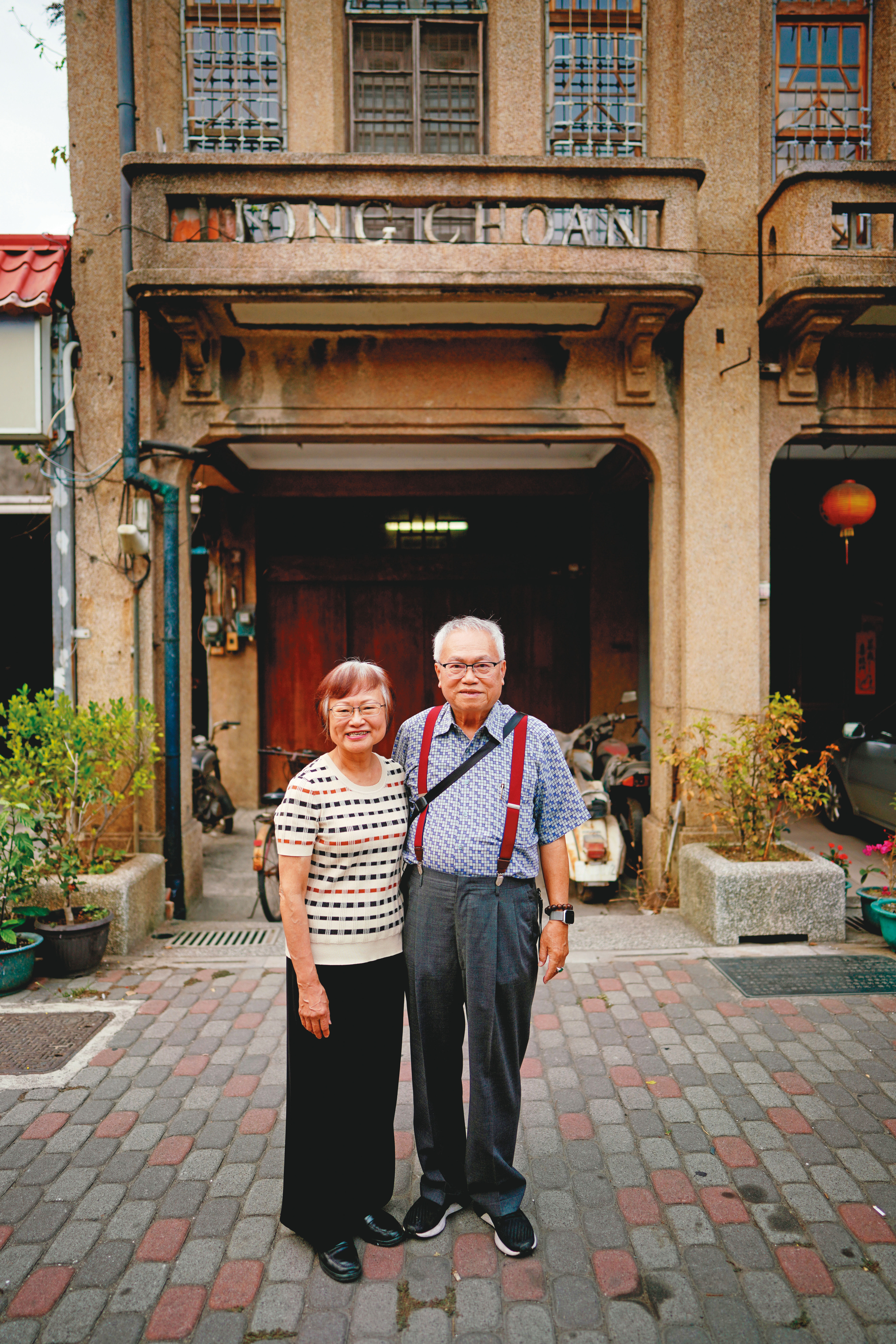 李雅容（左）與丈夫胡明和在童年故居門口合照。