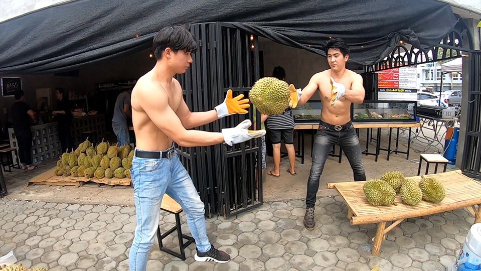 2名男子成了水果行的賣點，不過也有網友搞笑問，為什麼不戴口罩啊？（翻攝自「กูรู้..โลกรู้ 」粉絲頁）