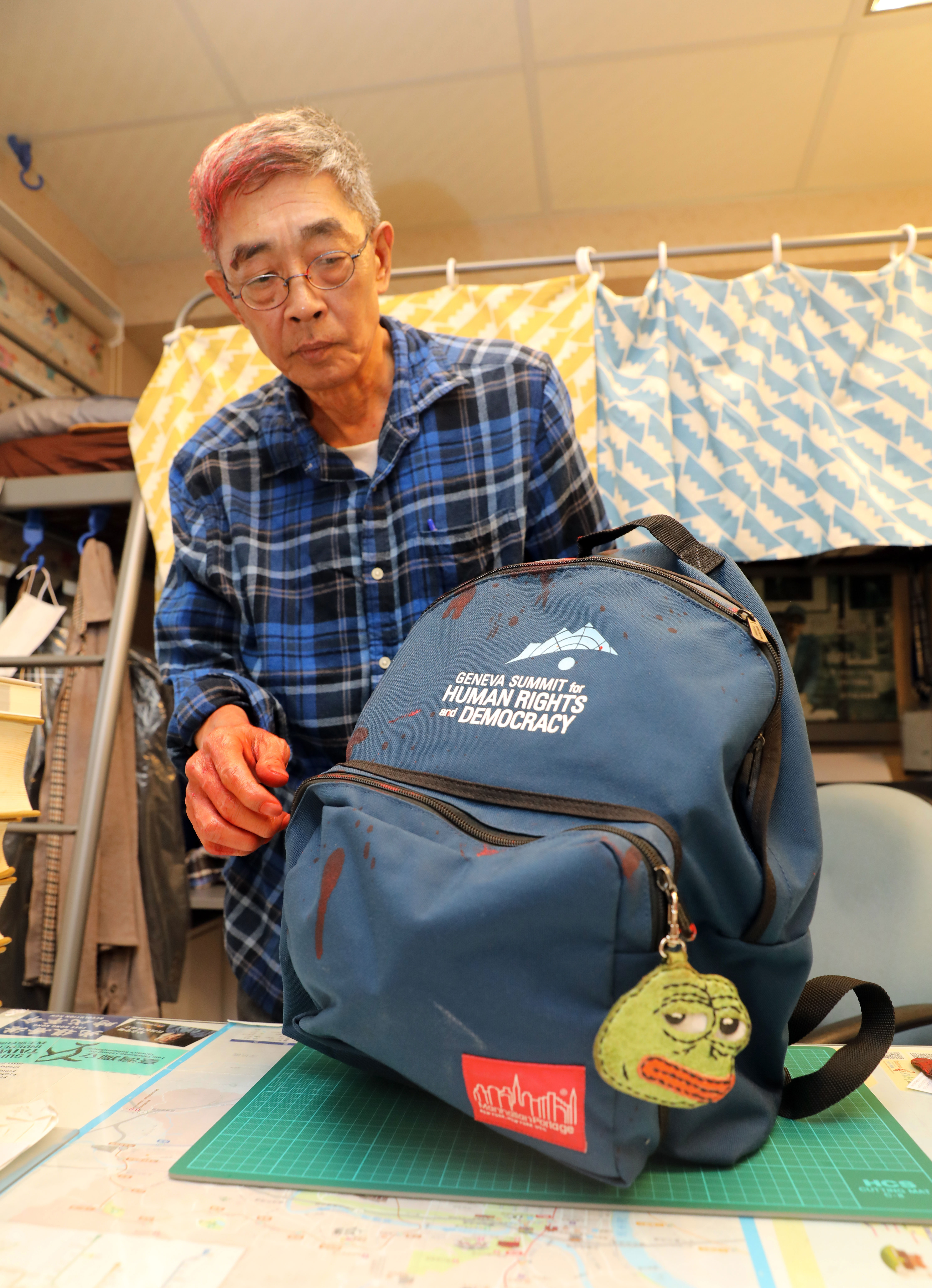 賣書佬的書包上有只搖頭晃腦的「pepe蛙」，那是一名年過7旬的香港婆婆親手縫製的。