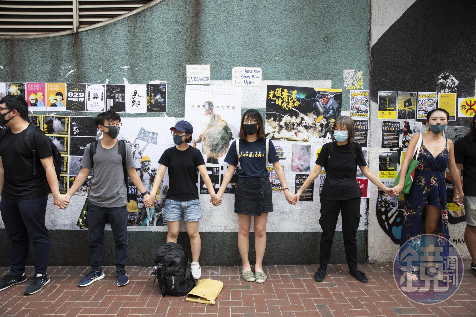 香港年輕勇武派大逃亡，不少人怕被秋後算帳，選擇前往台灣。圖為去年反修例運動期間，年輕的香港市民在香港修頓球場連儂牆牽起手。（本刊資料照）