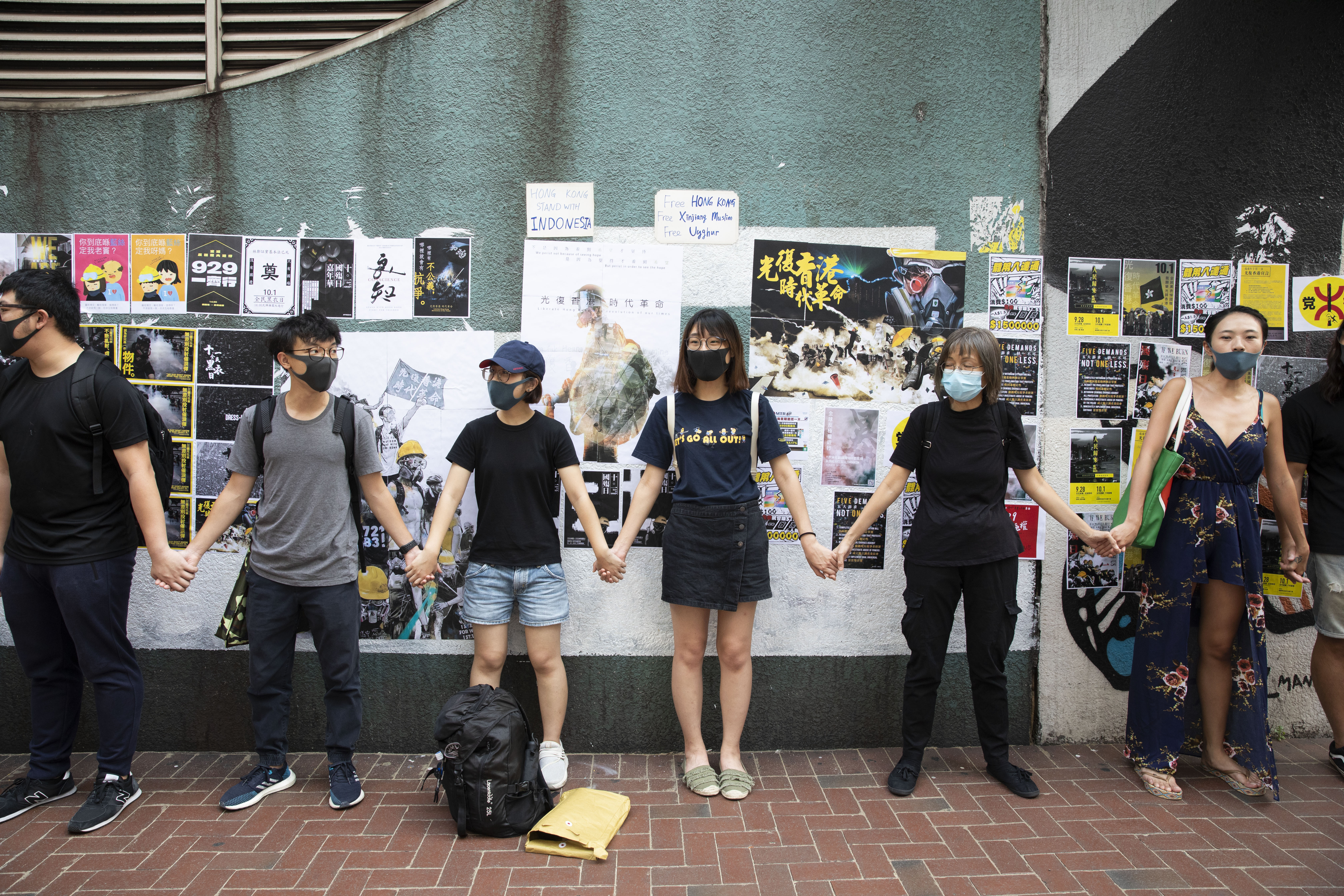 香港年輕勇武派大逃亡，不少人怕被秋後算帳，選擇前往台灣。圖為去年反修例運動期間，年輕的香港市民在香港修頓球場連儂牆牽起手。（本刊資料照）