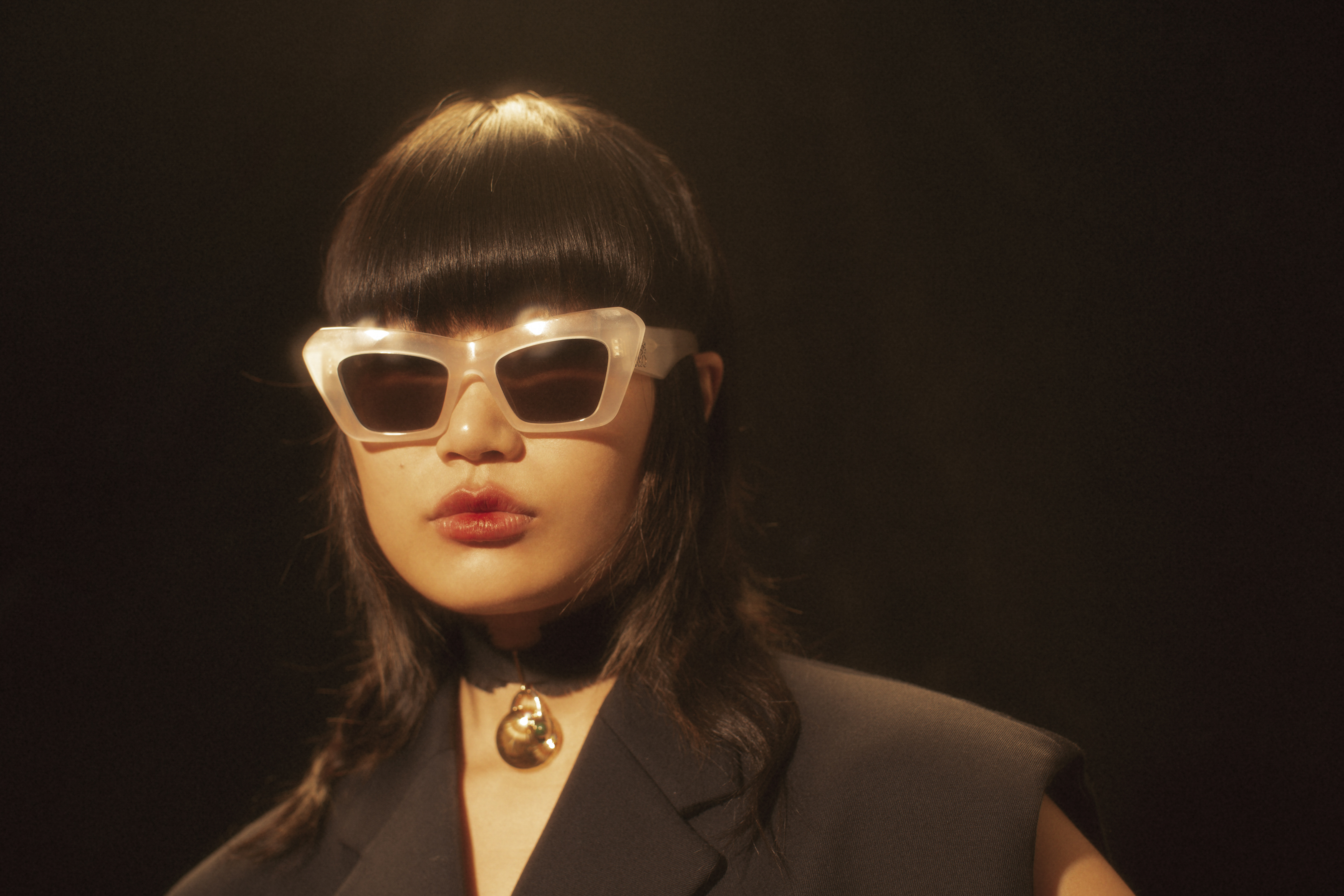 白色膠框太陽眼鏡 NT$10,300 by LOEWE、黑色頸環 NT$22,300 by Chloé、黑色西裝背心 NT$83,500 by MIU  MIU。