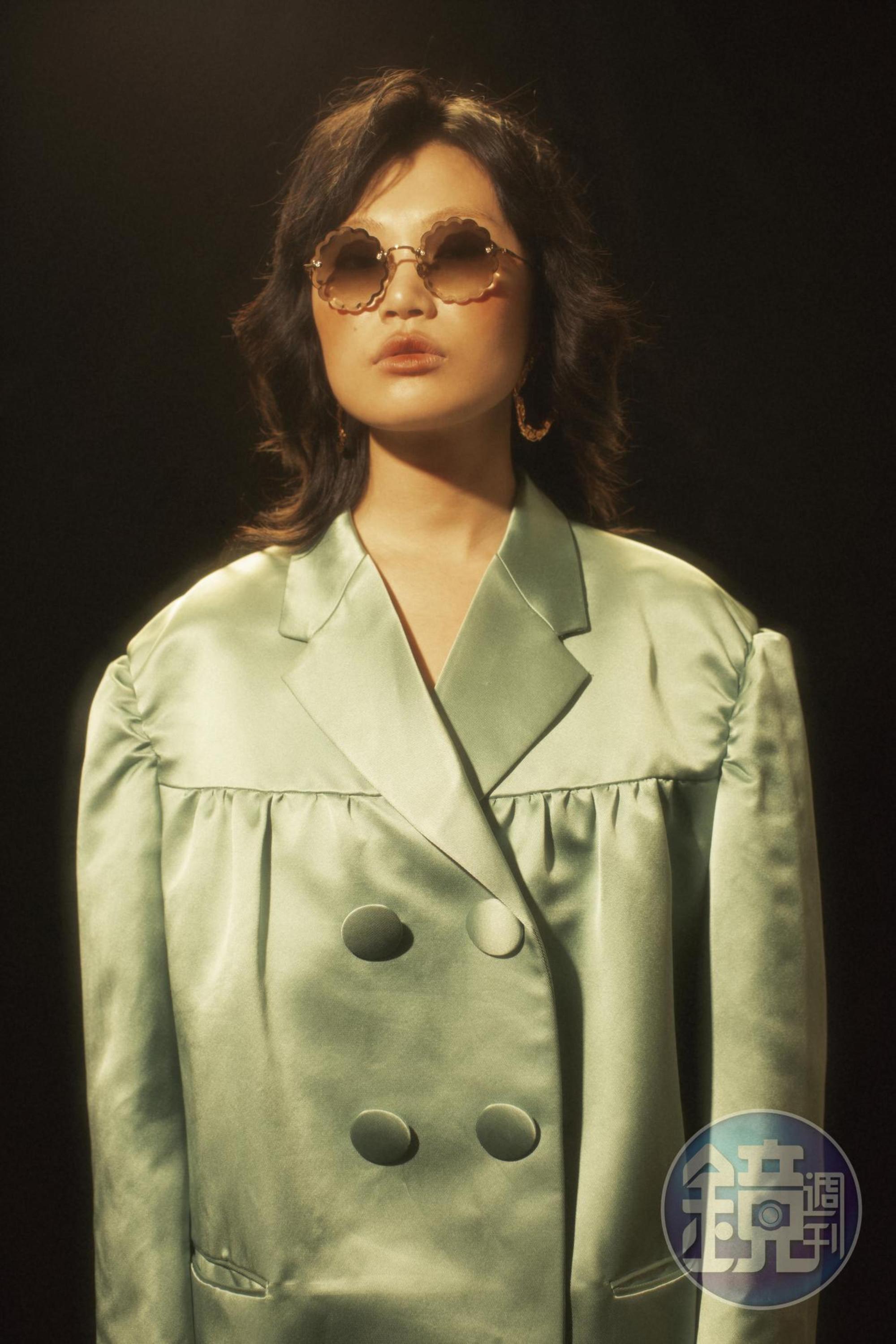花朵形漸層太陽眼鏡 NT$18,300 by Chloé、金色耳環 價格店洽 by Chloé 、淺綠色oversize外套 NT$14,450 by MIU MIU。