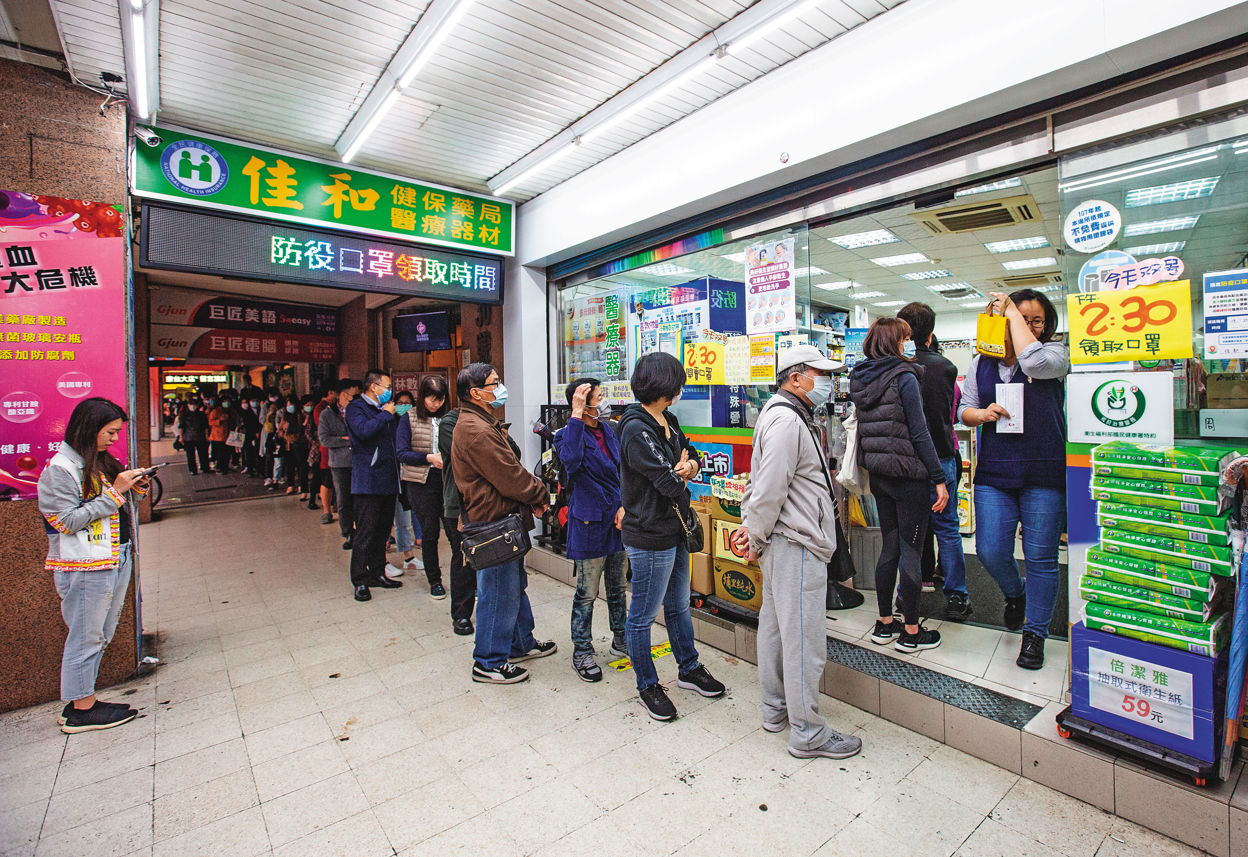 國內管制陸續解封，指揮中心呼籲民眾仍須堅守戴口罩、勤洗手等個人防線。圖為民眾在藥局排隊買口罩。