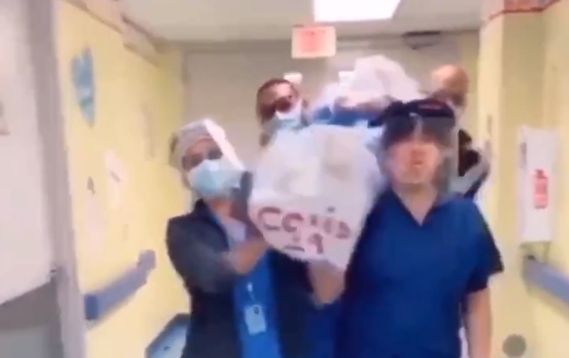 美國有醫護人員抬著寫有COVID-19的屍袋大跳「抬棺舞」。（翻攝自推特@realjuliasong）