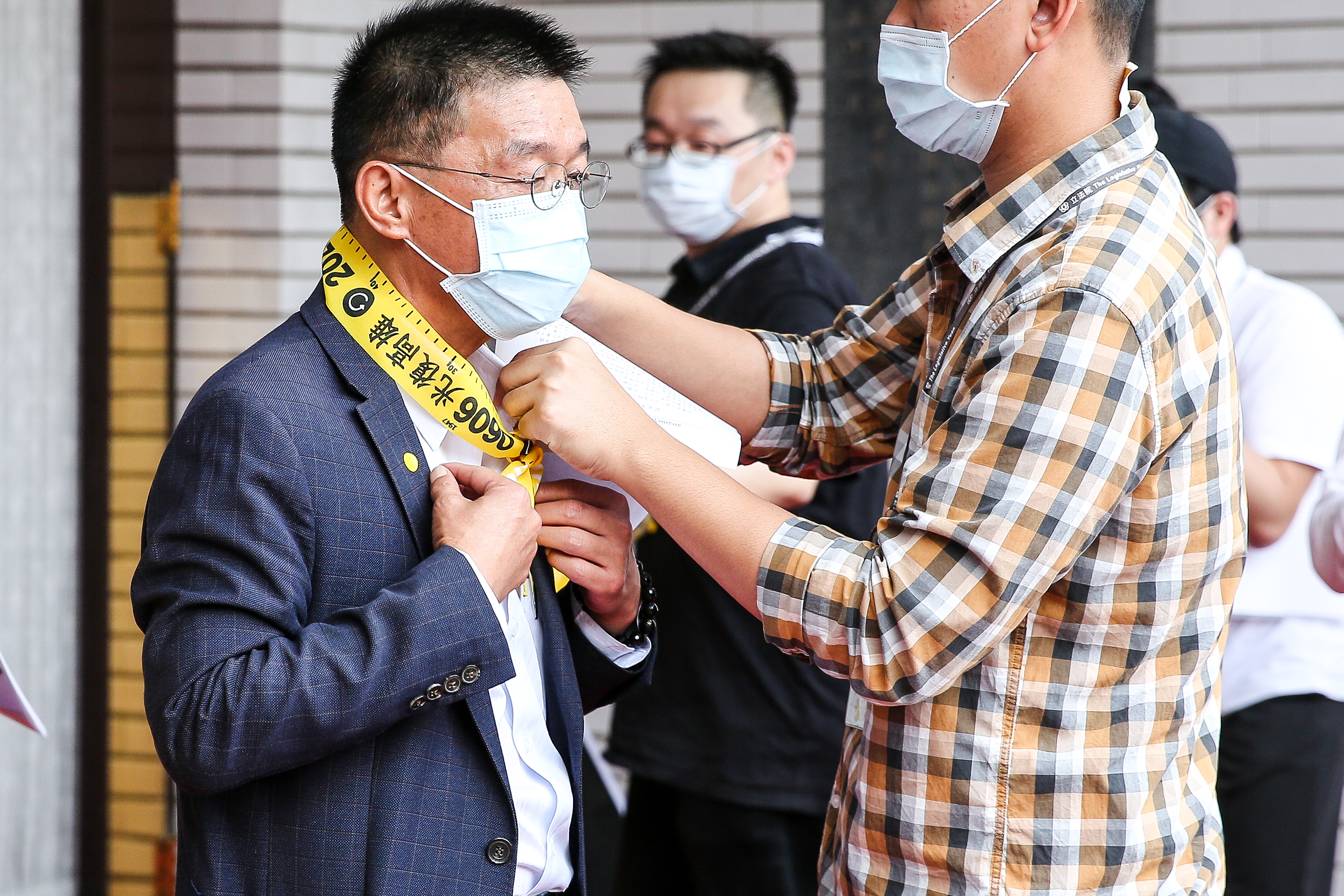 今天出席記者會的立委都在脖子上繫了一條長1公尺的光復高雄社交距離布條。