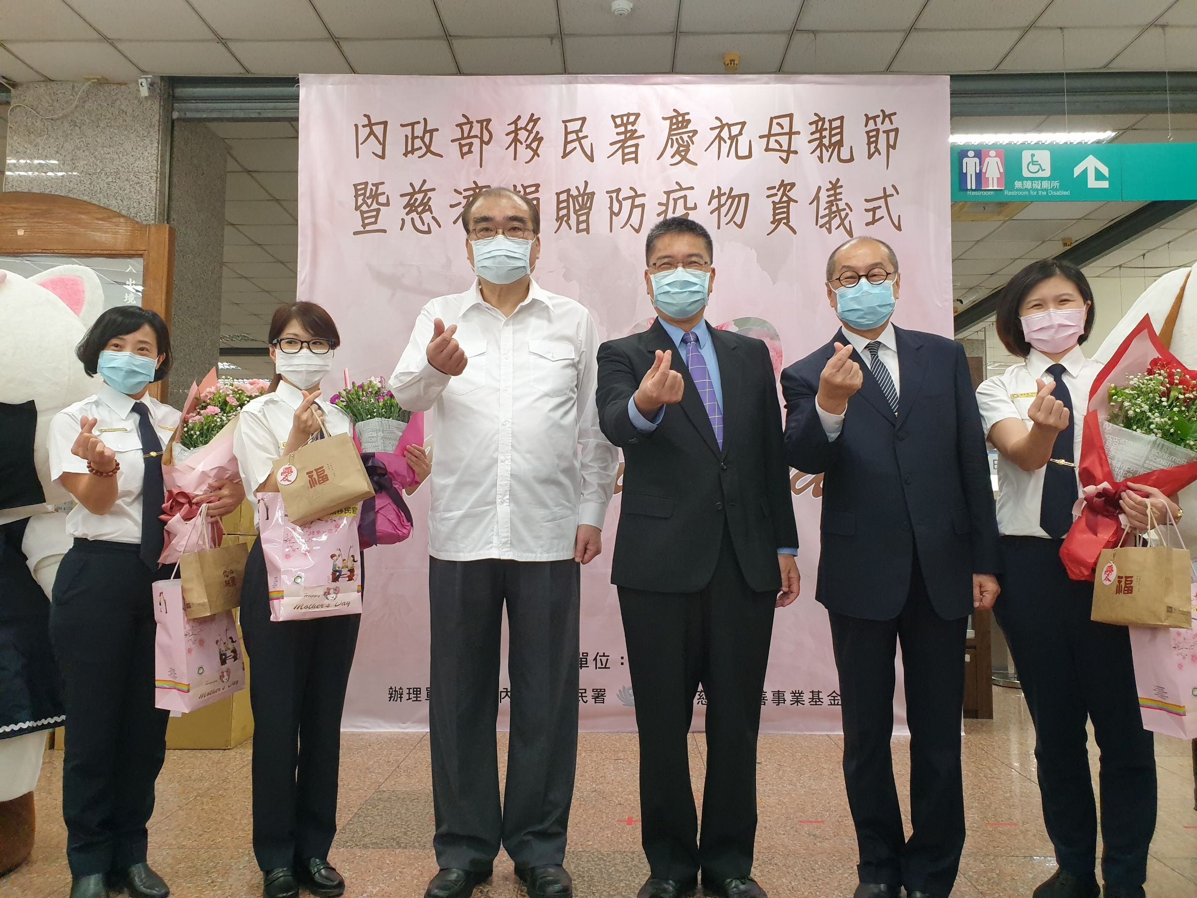內政部長徐國勇（右3）、移民署長邱豐光（右4）及慈濟基金會副執行長劉銘達（右2），共同贈送康乃馨花束、禮品及防疫小包給第一線移民官媽媽。（移民署提供）