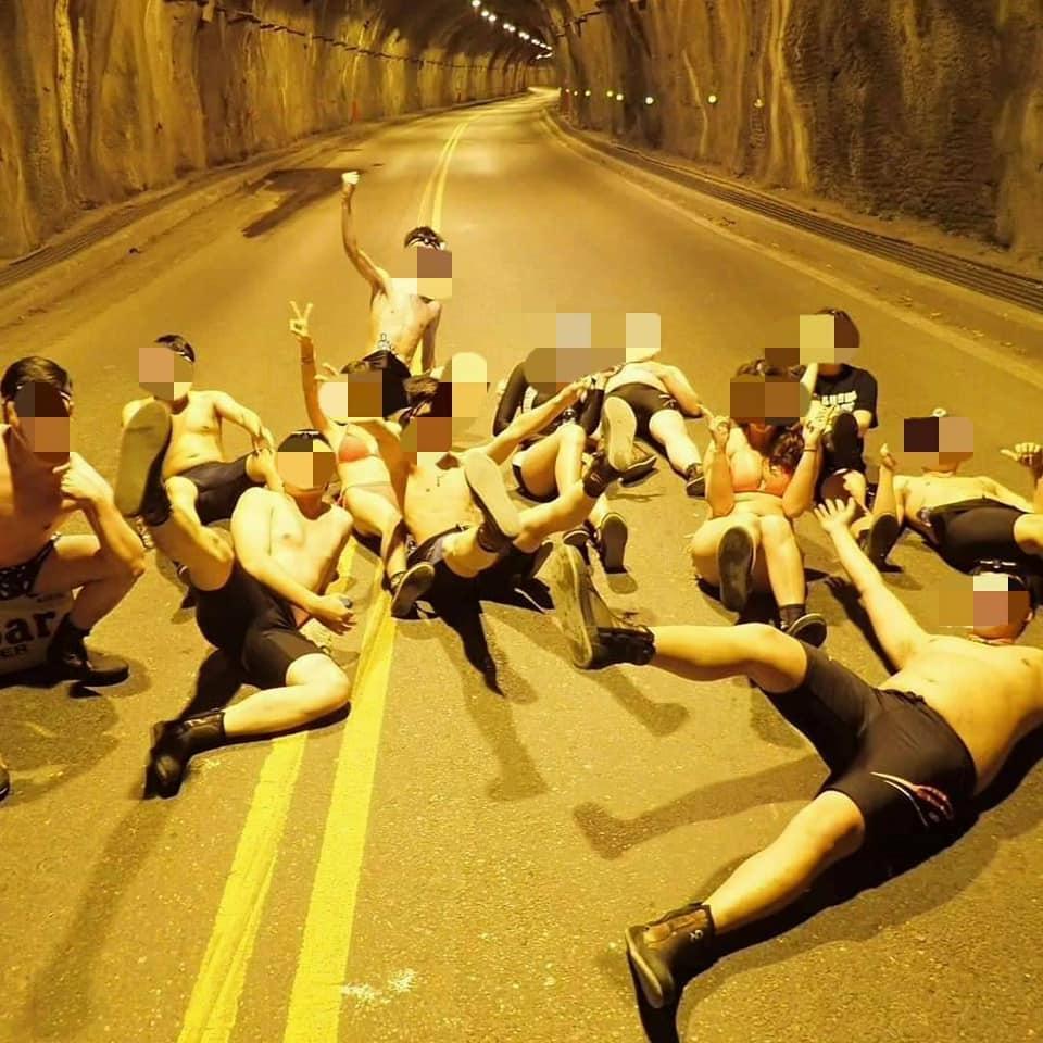 民宿業者帶遊客私闖已封閉的文山溫泉，一群人躺臥在馬路中央拍照也涉及《道路交通安全處罰條例》。（翻攝自劉粉哥臉書）