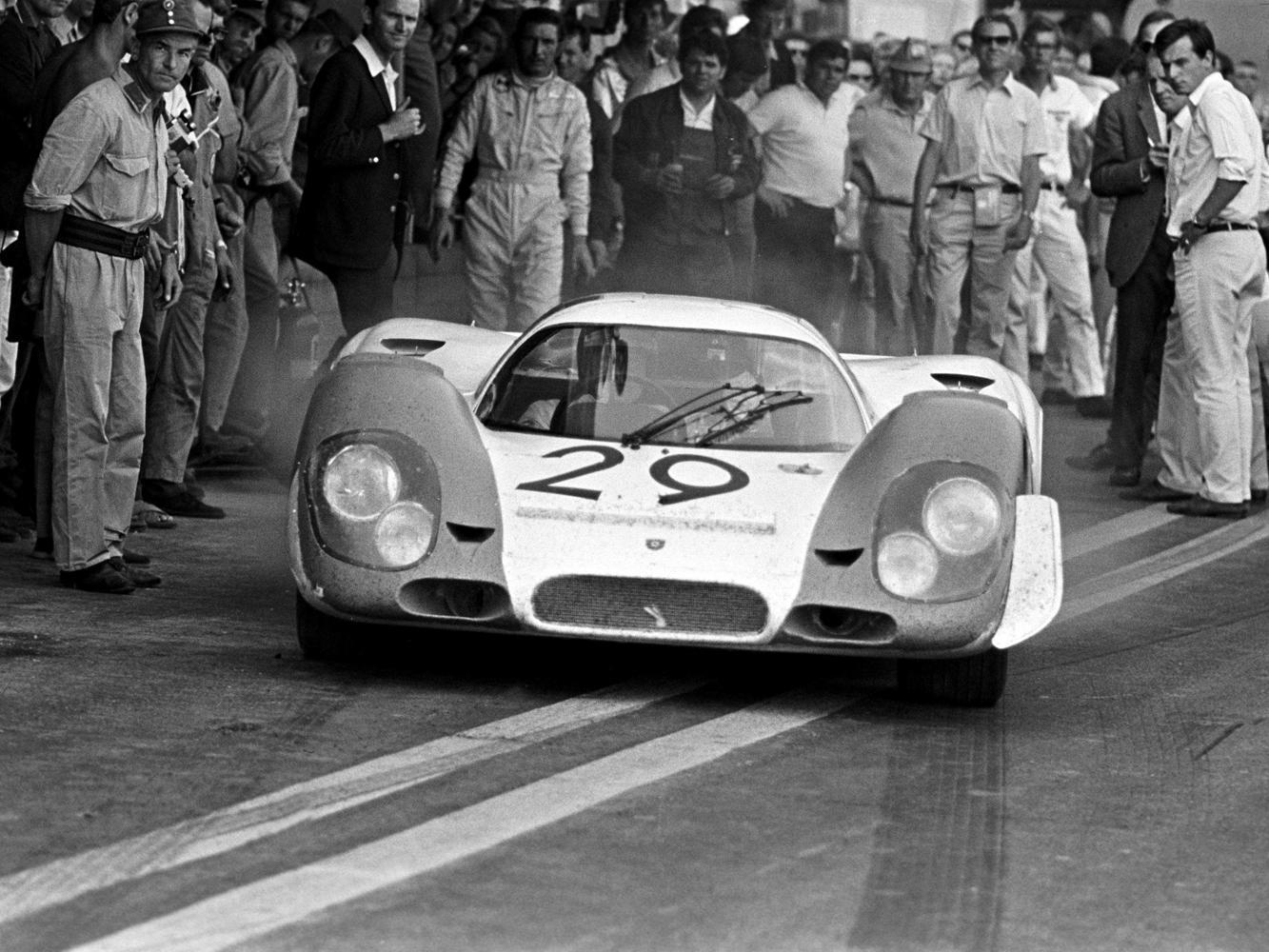 Kurt Ahrens於1969年8月10日駕駛 Porsche 917在奧地利紅牛賽道（Österreichring circuit）。站在917車後為Jo Siffert，而他左方著深色夾克為Ferdinand Piëch。