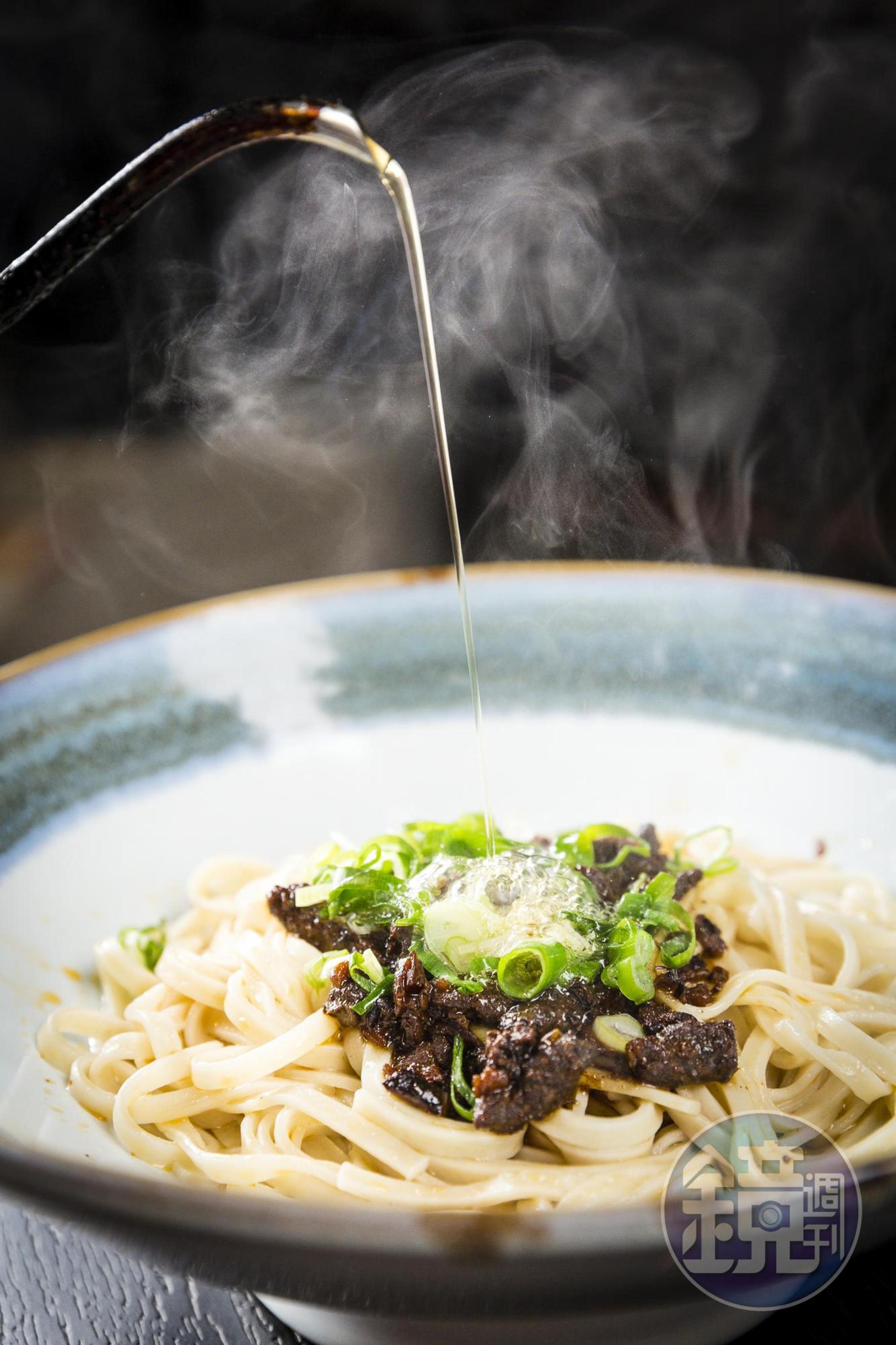 放上獨門椒麻和牛肉燥，撒點蔥花，最後再淋上滾燙的牛油，香味瞬間四溢。(和牛乾拌麵套餐/180元 附雞湯及小菜)