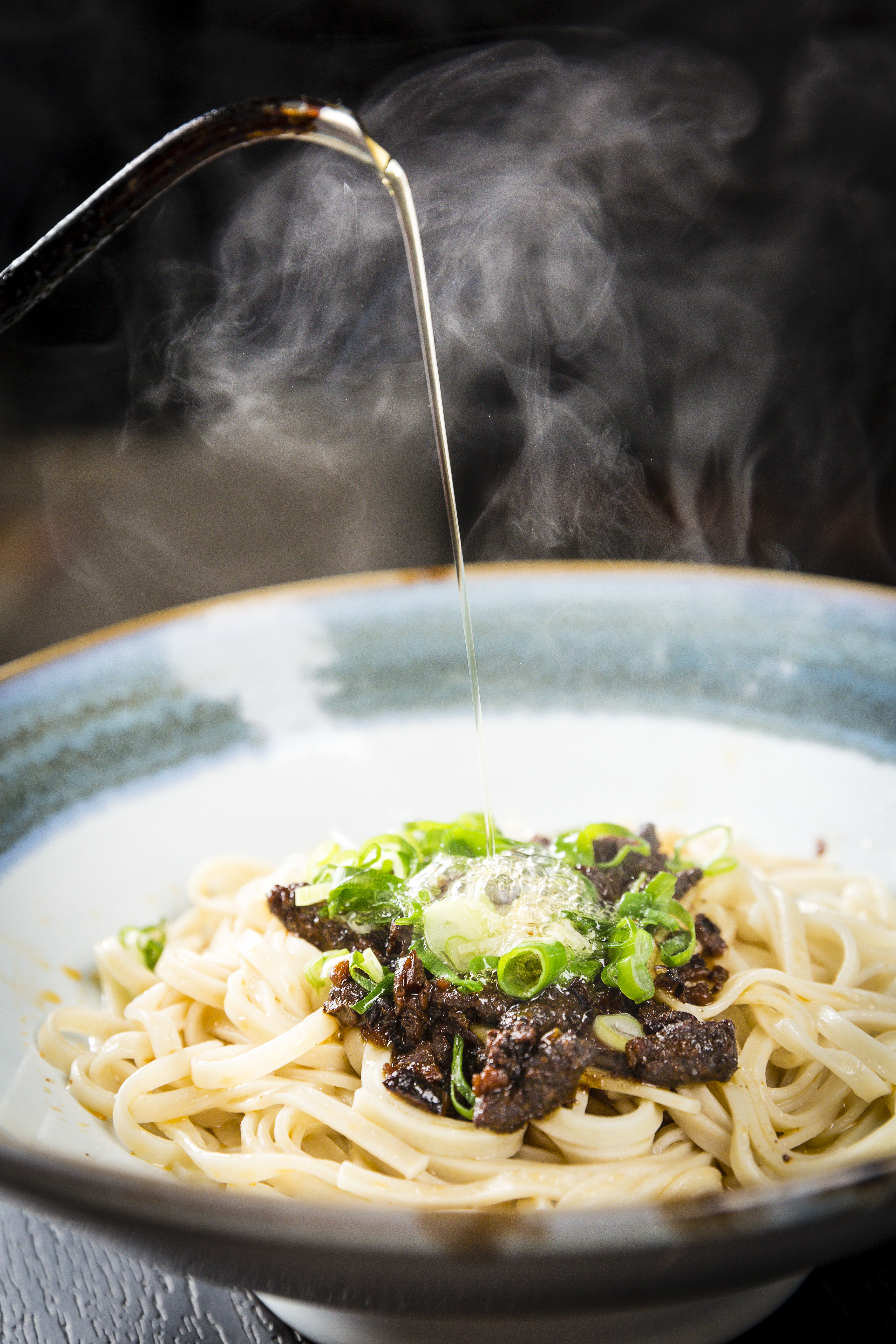 放上獨門椒麻和牛肉燥，撒點蔥花，最後再淋上滾燙的牛油，香味瞬間四溢。(和牛乾拌麵套餐/180元 附雞湯及小菜)