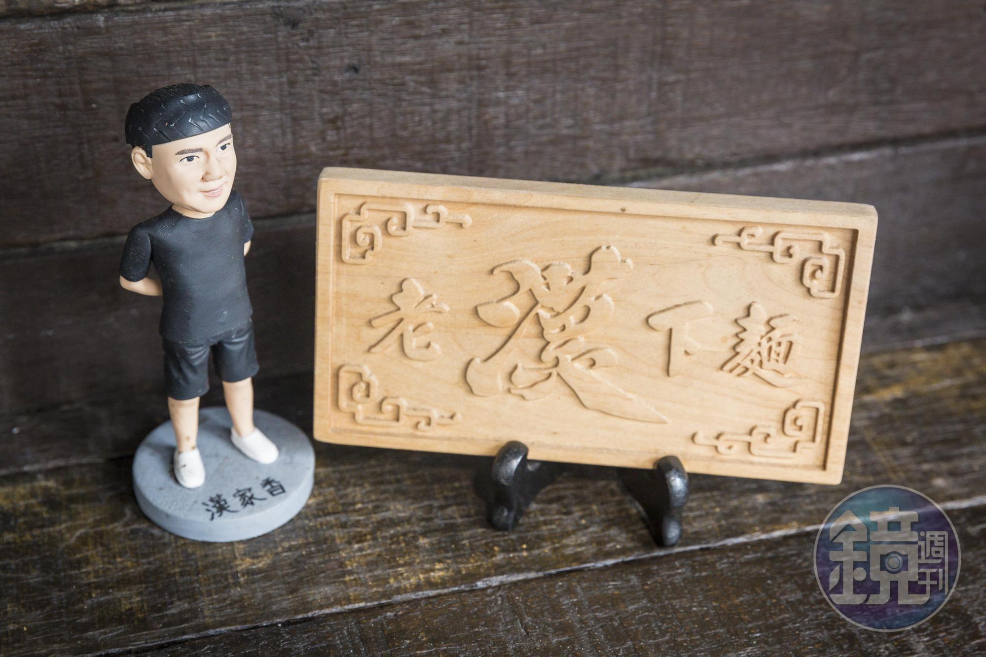 去年開實體店面時，監獄管理員送他一個「老漢下麵」迷你匾額。就擺在店裡長桌一角。