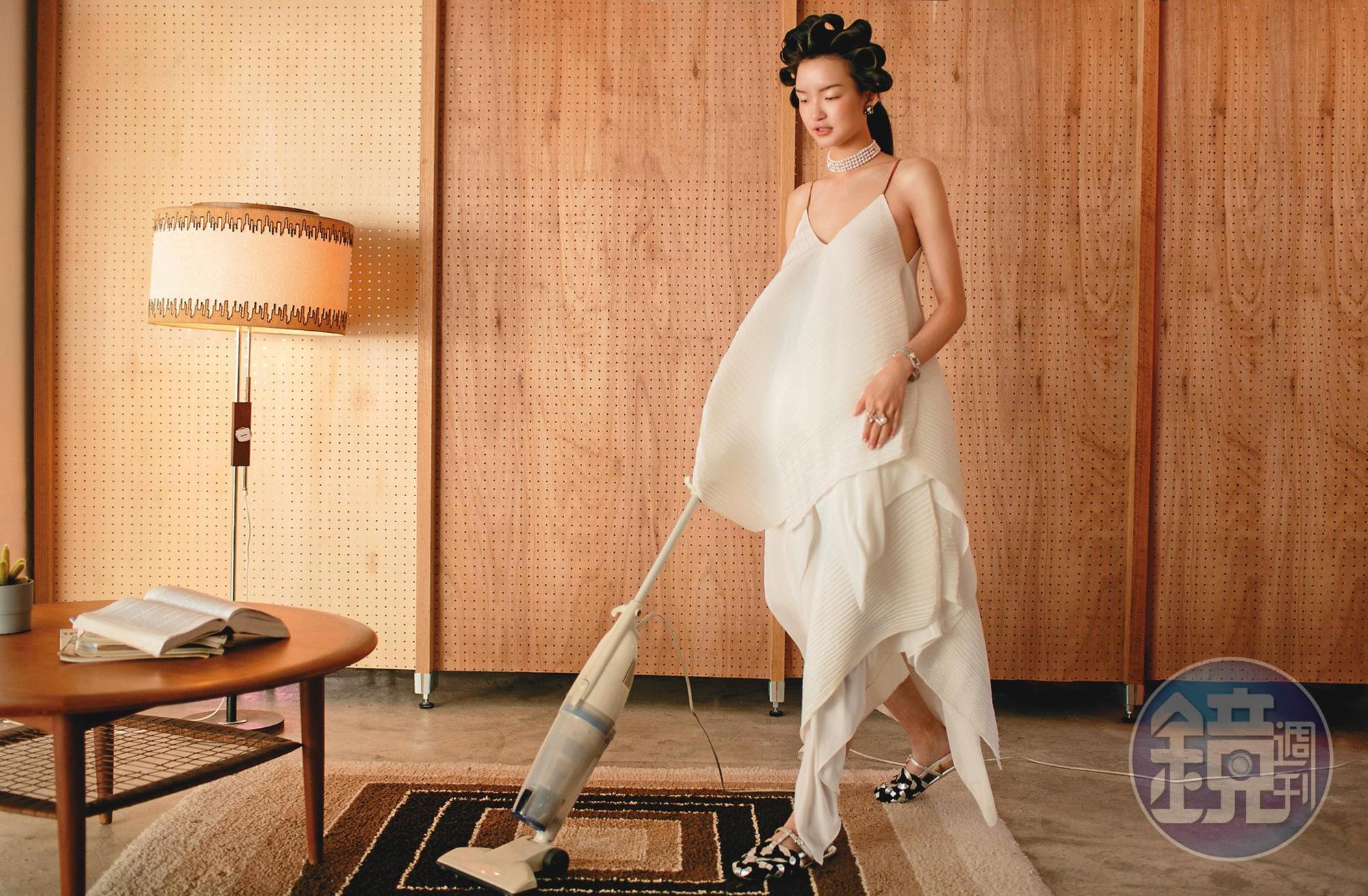 白色細肩帶傘狀背心 NT$46,000 by LOEWE／白色不規則裙襬長裙 NT$51,000 by LOEWE／銀黑色涼鞋 NT$32,000 by PRADA／大溪地黑珍珠鑽石耳環 價格店洽／日本AKOYA珍珠鑽石頸鍊 價格店洽／ART-DECO鑽石手鍊 價格店洽／（左）弧線鑽戒 價格店洽／（右）南洋珍珠交錯鑽戒 價格店洽 All by GEMMIE JEWELRY。