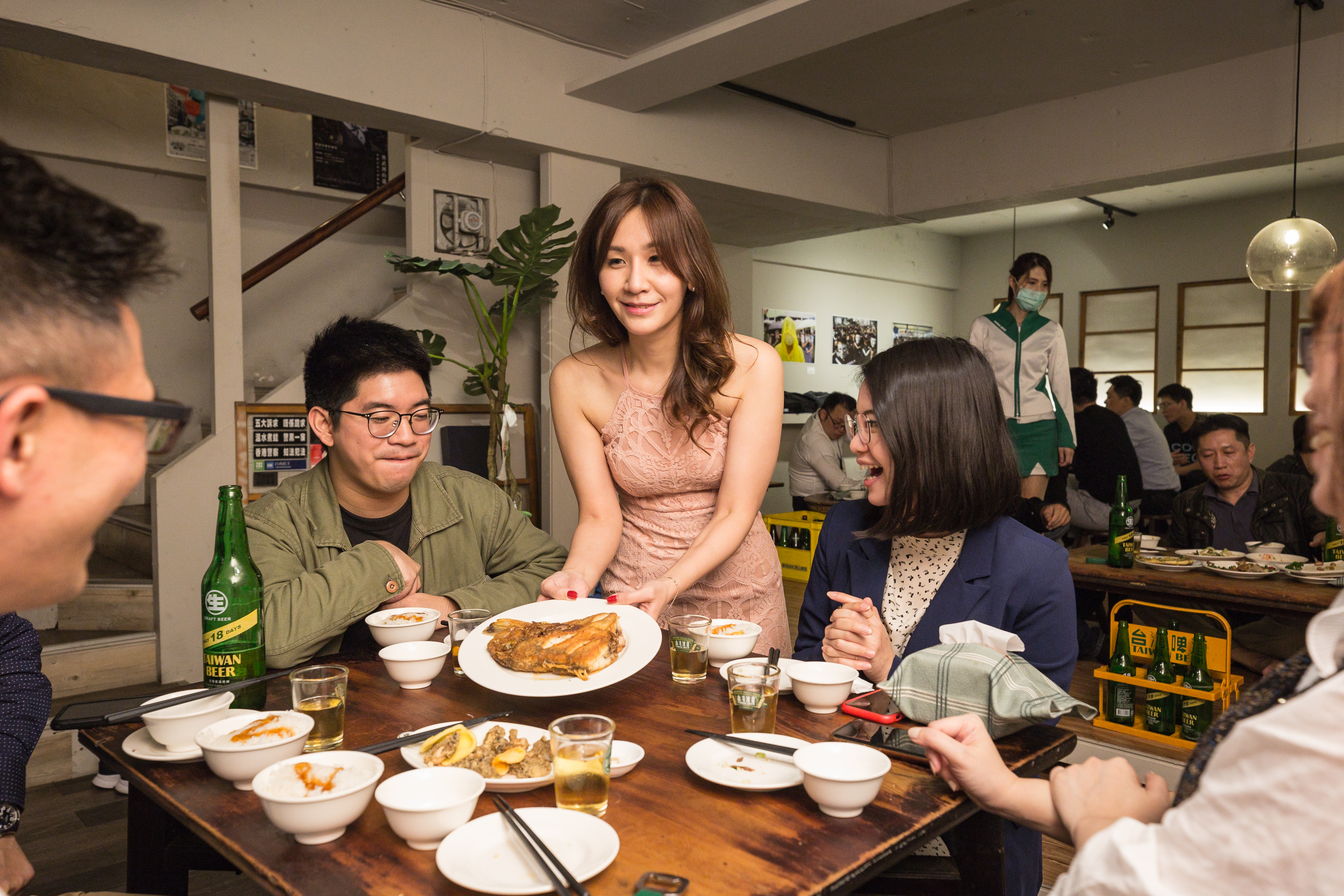 楊怡欣（中）穿著一襲粉色削肩洋裝招呼客人，打扮亮眼入時的她，是店內的焦點。