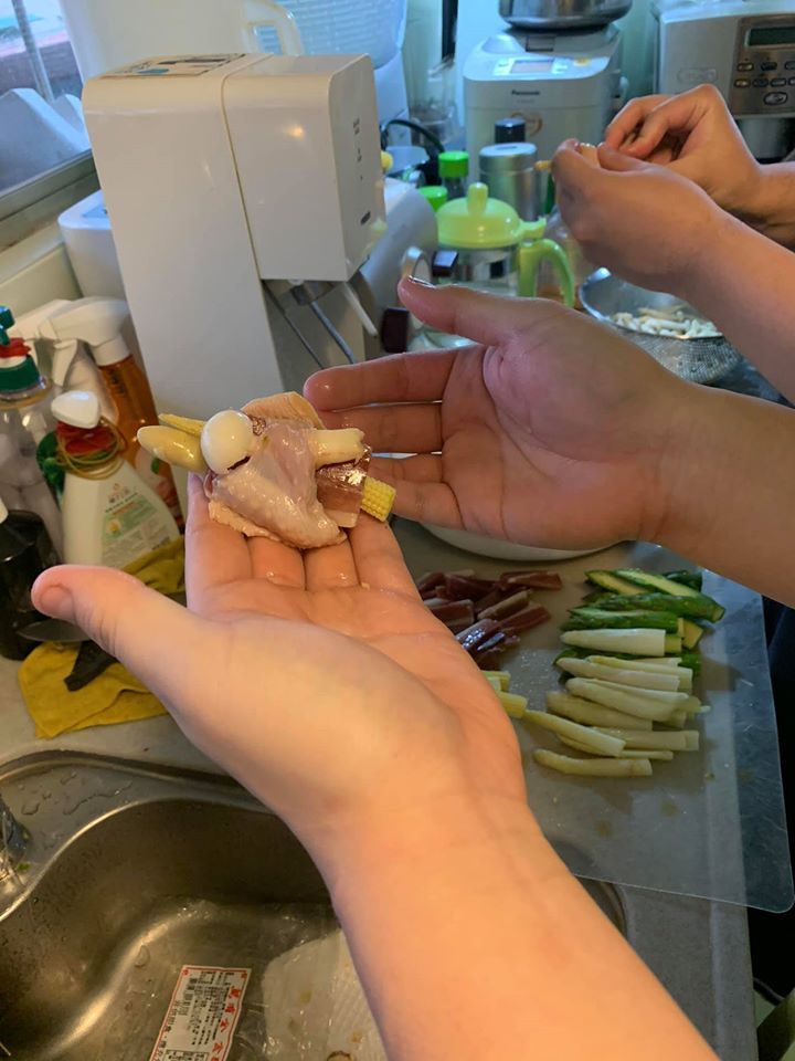 下廚是家庭活動，兒子們在穿雞翼。