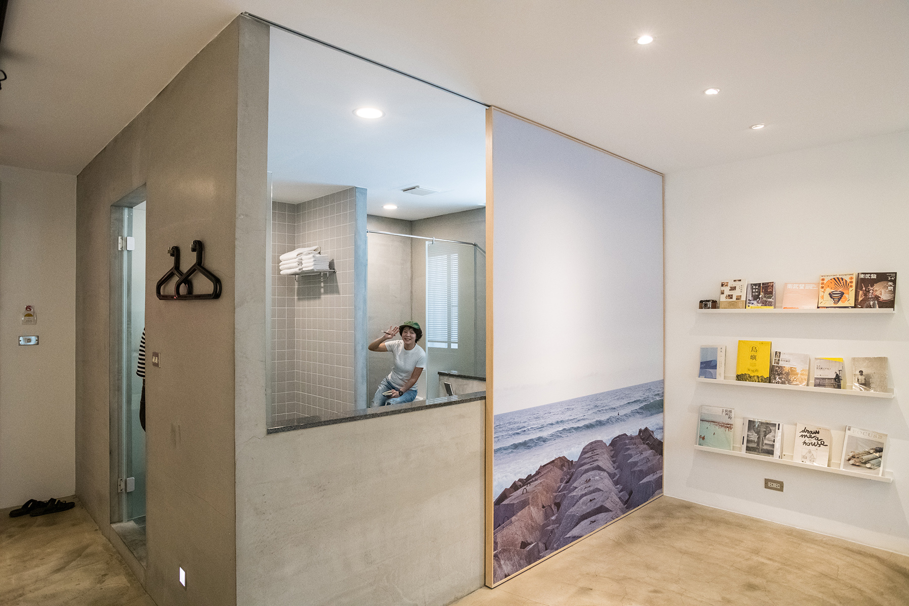 將浴室與臥室分隔的移動牆面，使用攝影師黃見達的作品，堆疊的消波塊呈現工業港都的樣貌。