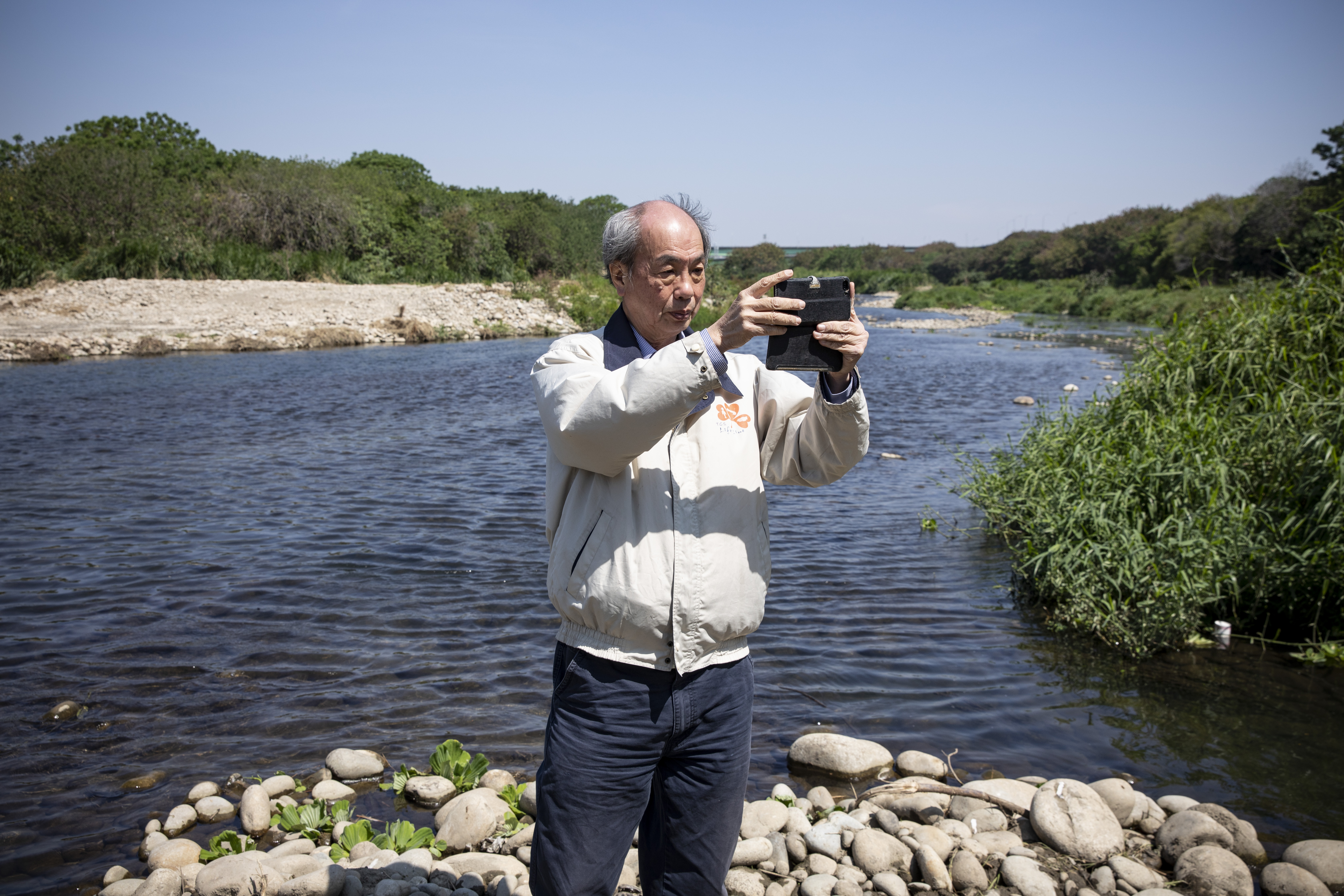 張豐年經常到各大溪流沿岸踏查拍照，他專挑無人之境，曾因此被砂石業者、養殖業者誤會要舉報不法行為。
