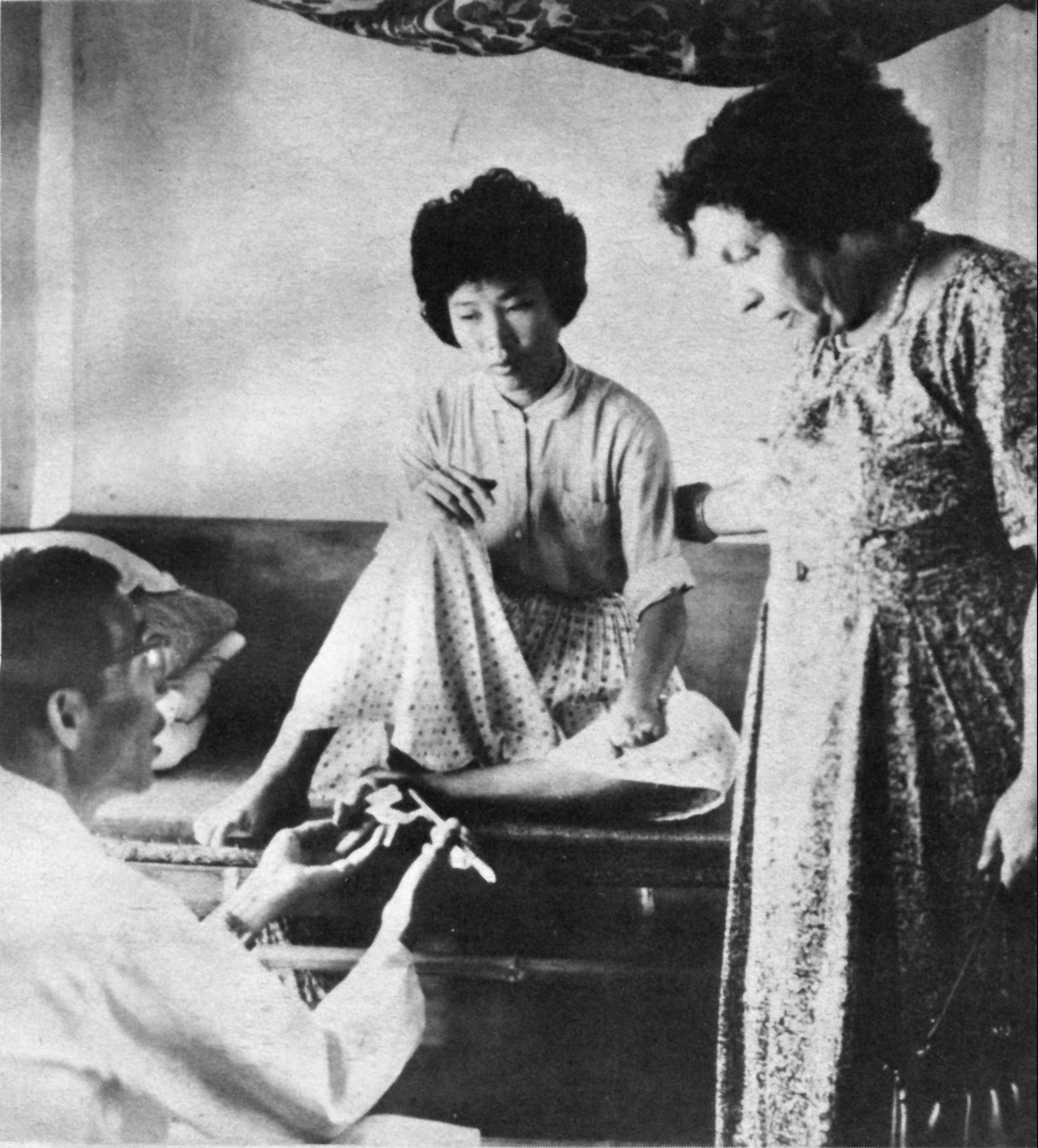 孫理蓮(右)探視烏腳病患者,王金河醫師(左)說明感染的情況。(基督教芥菜種會提供)