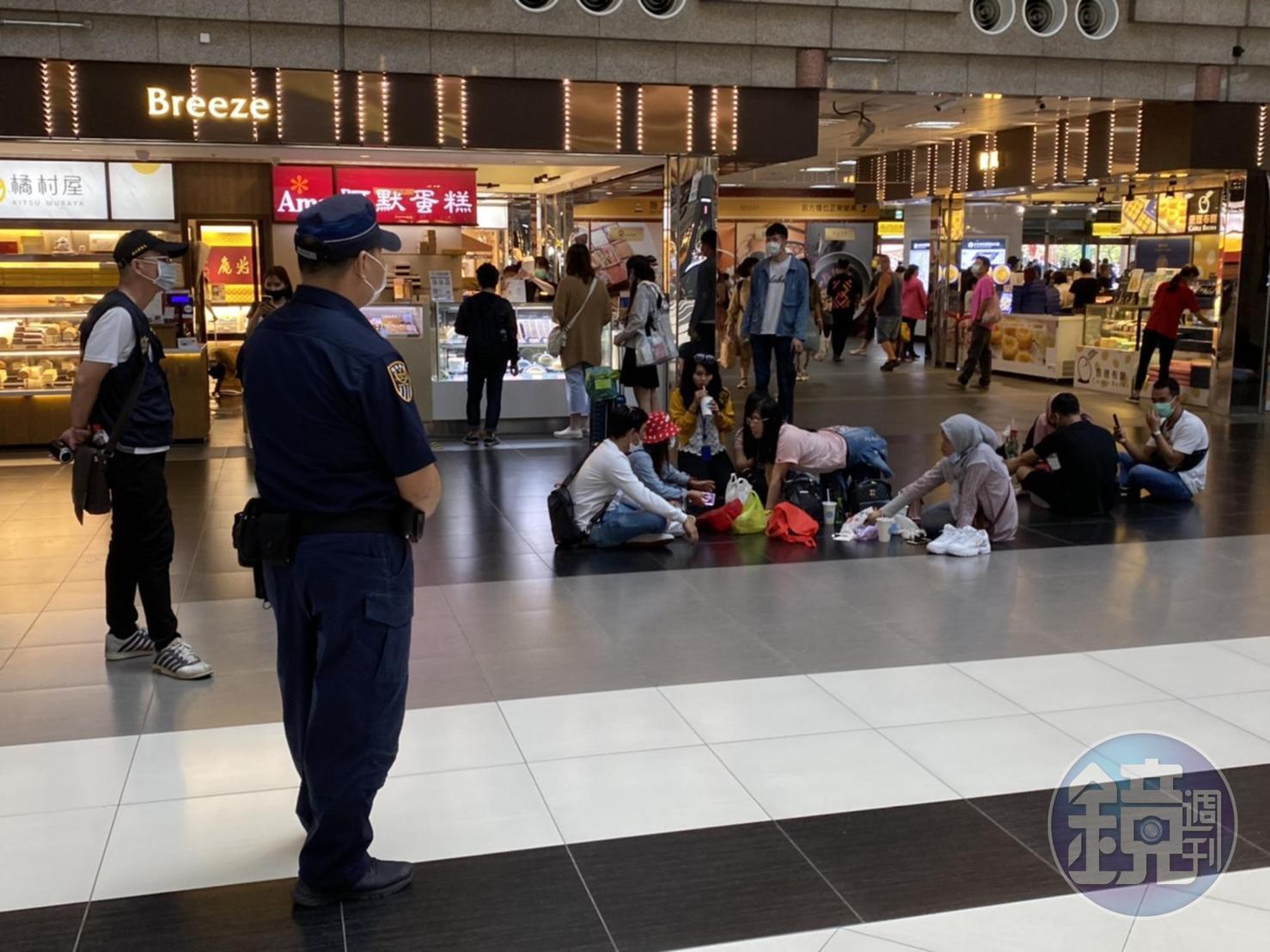 大廳黑白格被警方站崗防坐，移工朋友只好坐在大廳周圍。