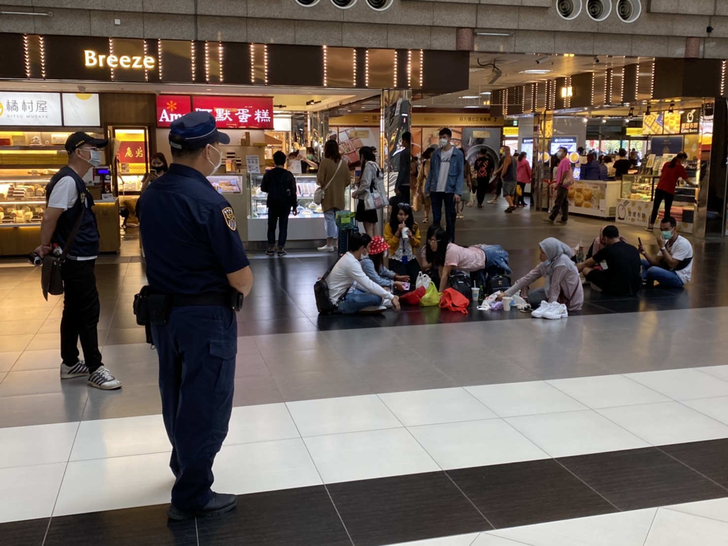 大廳黑白格被警方站崗防坐，移工朋友只好坐在大廳周圍。