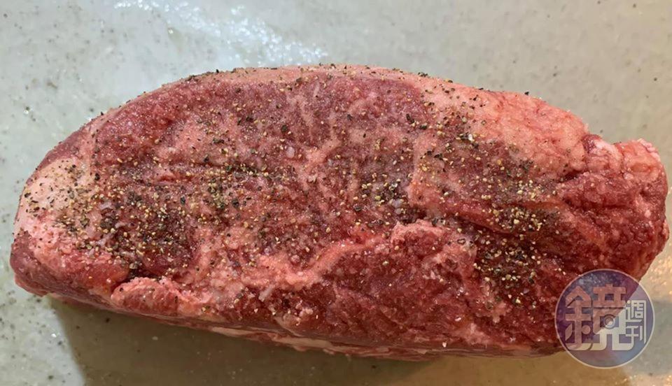 肋眼牛排抹上鹽和胡椒粒。