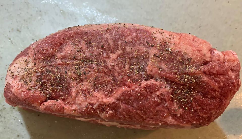 肋眼牛排抹上鹽和胡椒粒。